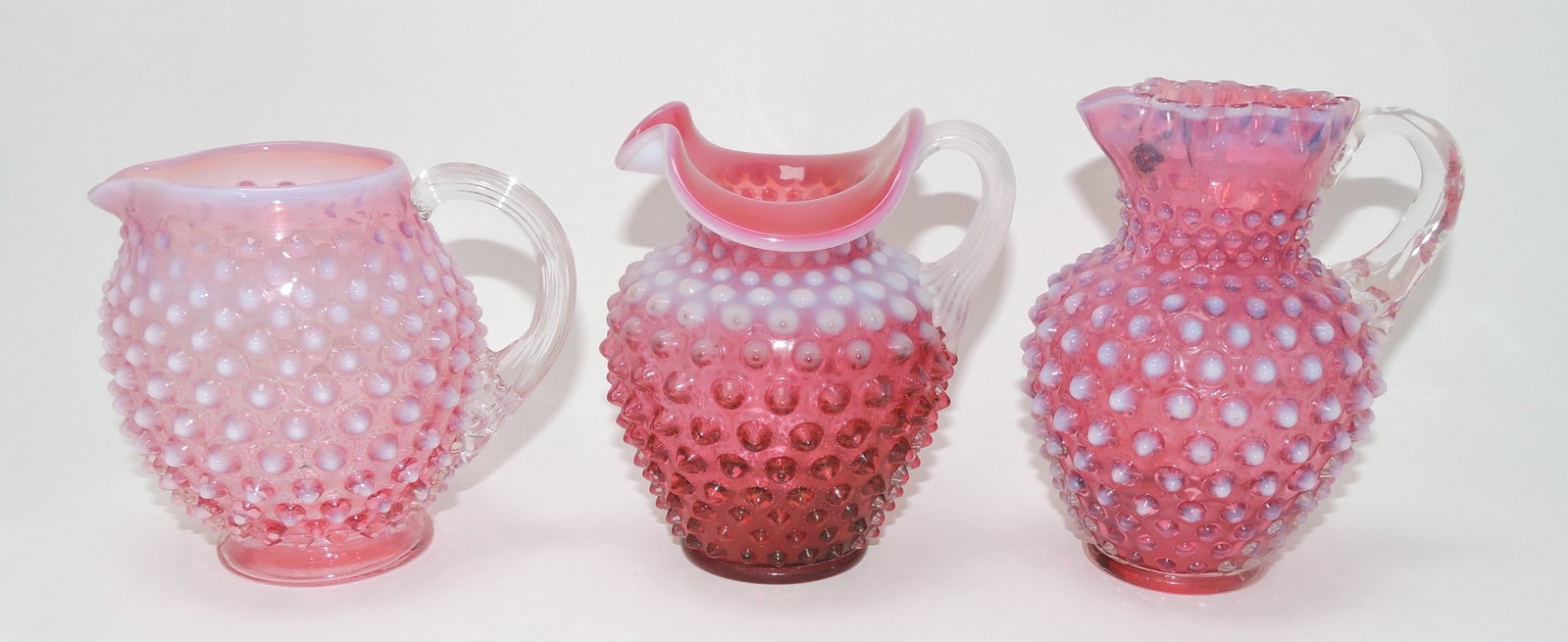 Fenton cranberry opalescent hobnail: lot of 3 pitchers, 4 3/4" to 5 3/4"