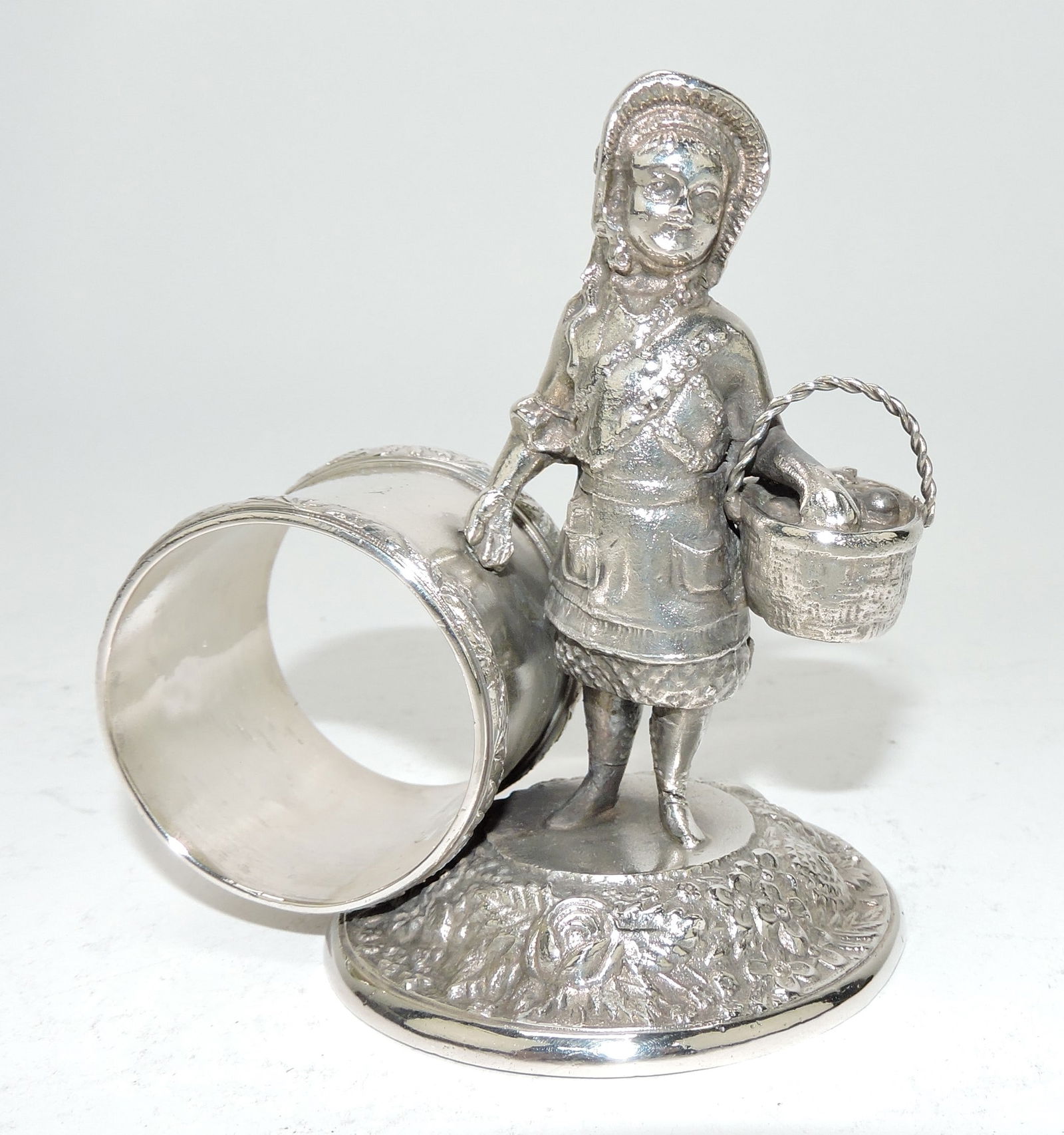 Pelton Bros silver plate figural napkin: ring with girl and basket, 4"