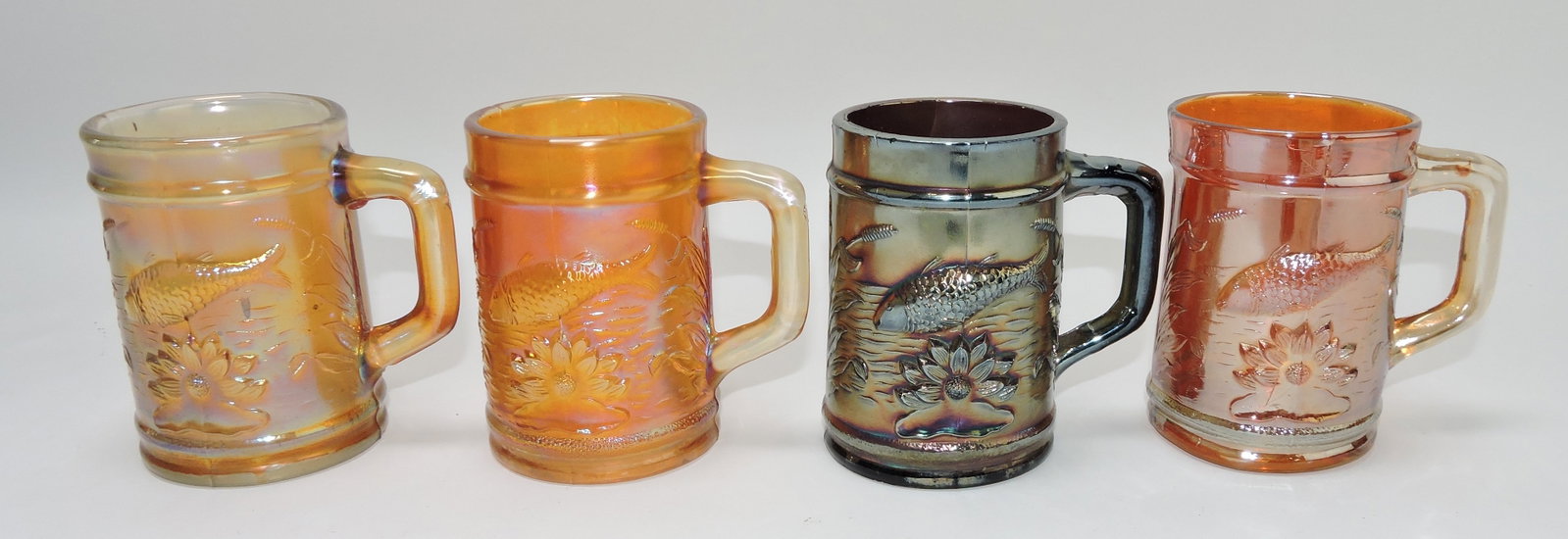 Dugan carnival glass lot of 4: Fisherman mugs, 1 amethyst, 3 marigold