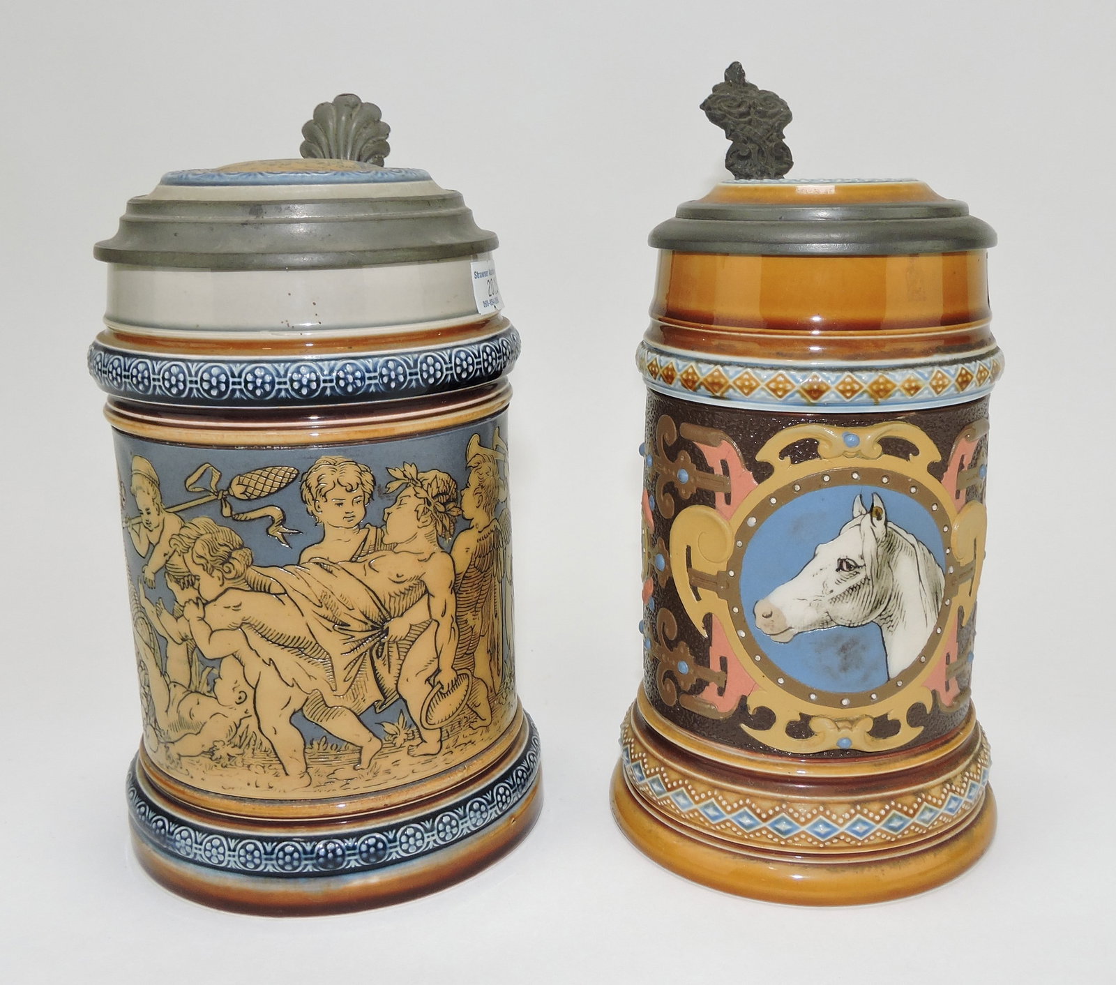 Mettlach lot of 2 steins, #2025 1/2L,: cherubs carousing AND #1454 1/2L, horse head