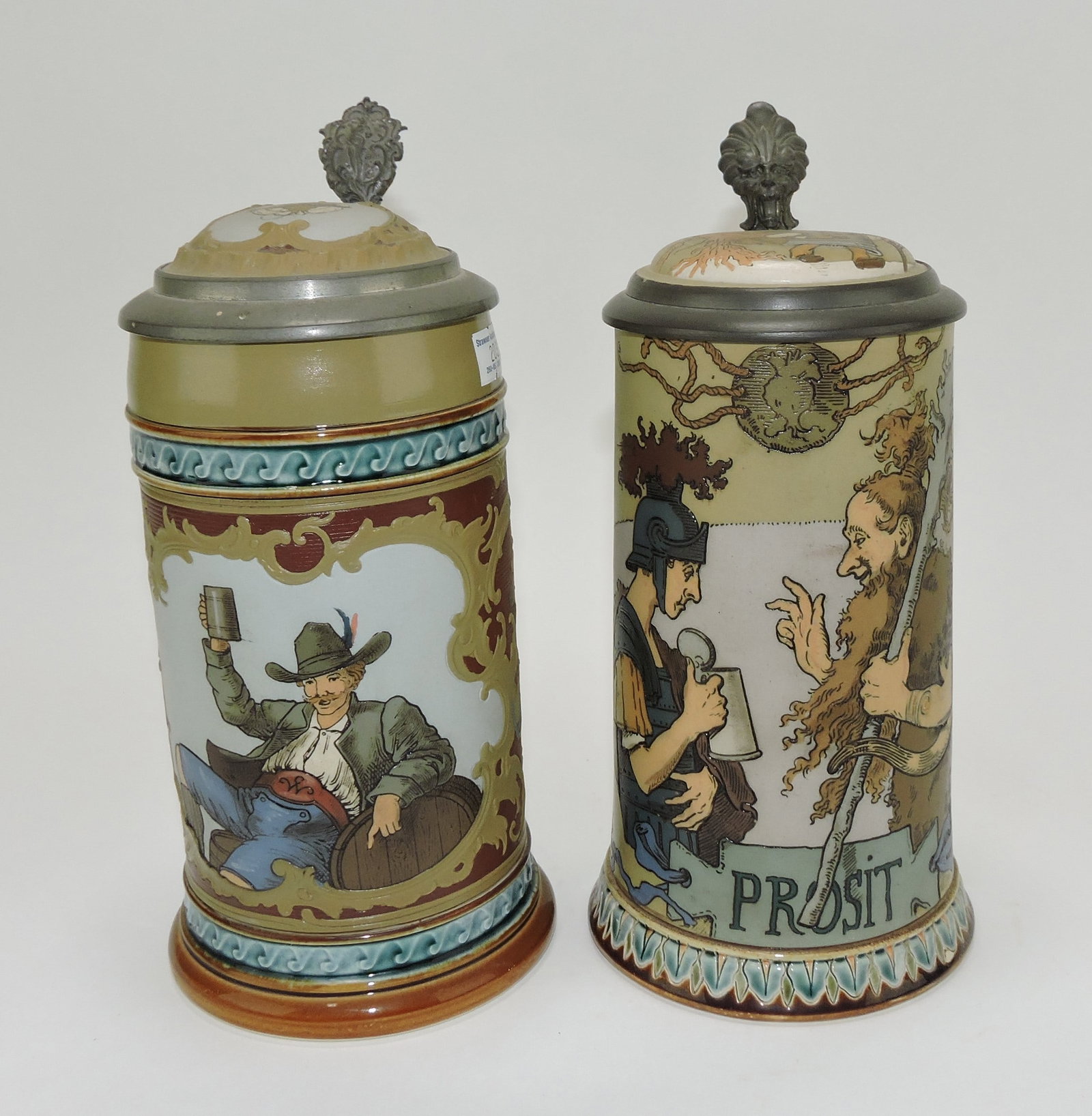 Mettlach lot of 2 steins, #2054 1/2L,: man toasting AND #2100 1/2L, Prosit