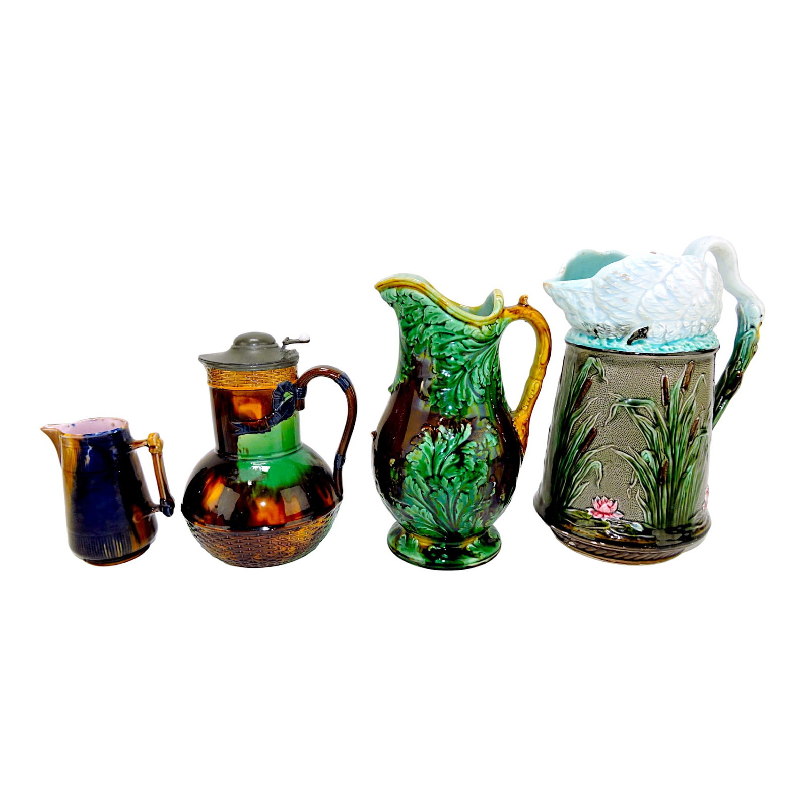 Majolica lot of 4 pitchers: 4 1/2" mottled: creamer, 7" Brownfield syrup jug, Wedgwood leaf pitcher, and swan topped pitcher