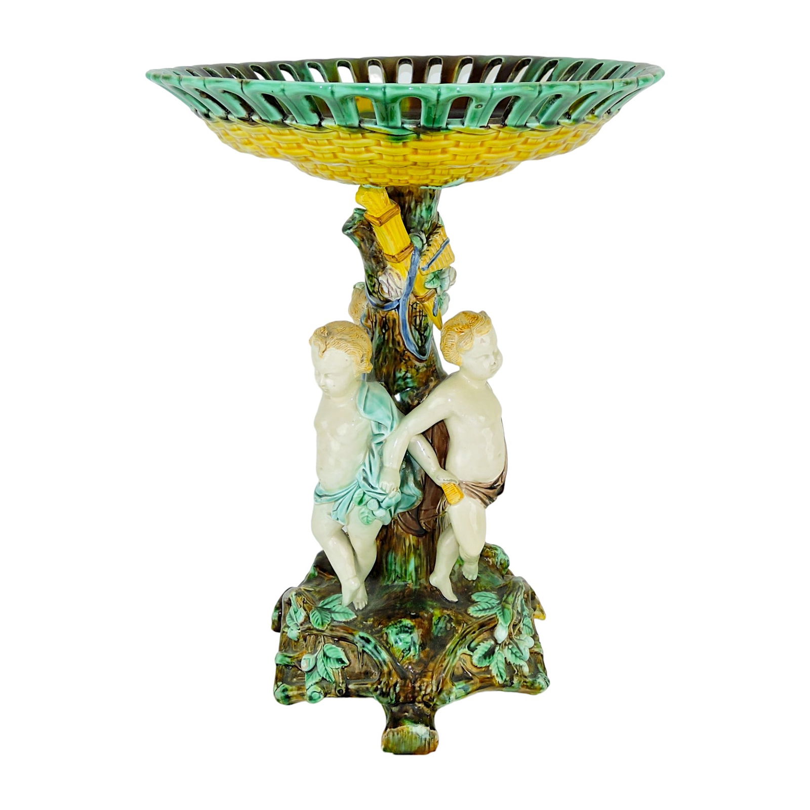 Large Wedgwood Majolica Centrepiece: c.1865, modelled as three draped boys facing outward against a tree trunk column with draped quiver supporting a basket weave bowl above, all upon an earthy base supported by three branch feet; 16"h,