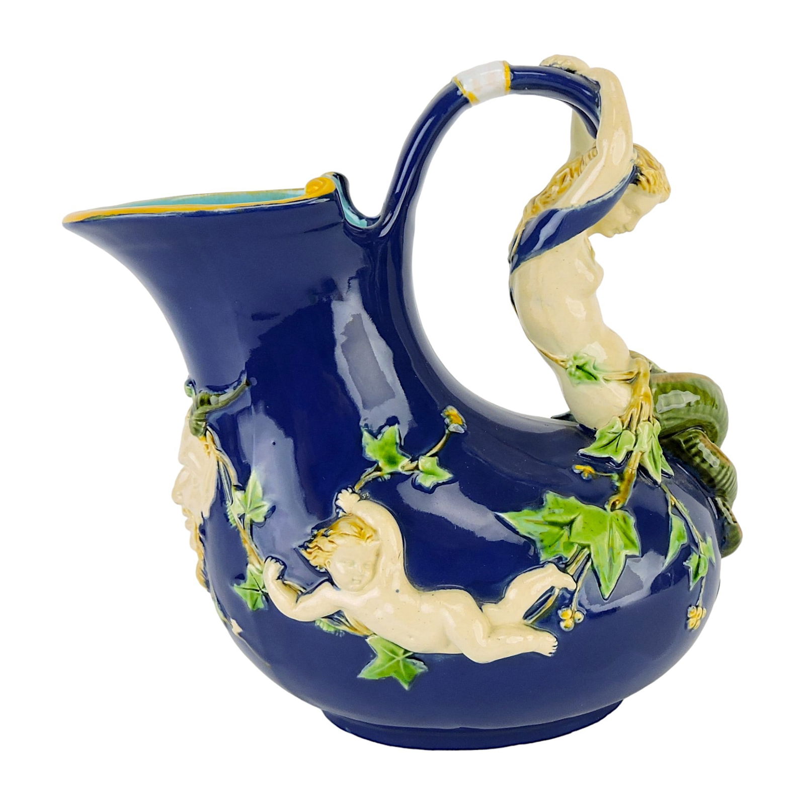 Minton Majolica Neried Ewer c.1875,: after a Pompeiian form with nereid loop handle, the body molded with putti holding ivy garlands suspended from a satyr mask below the spout. 8 1/2". A similar example was shown at the Philadelphia Cen