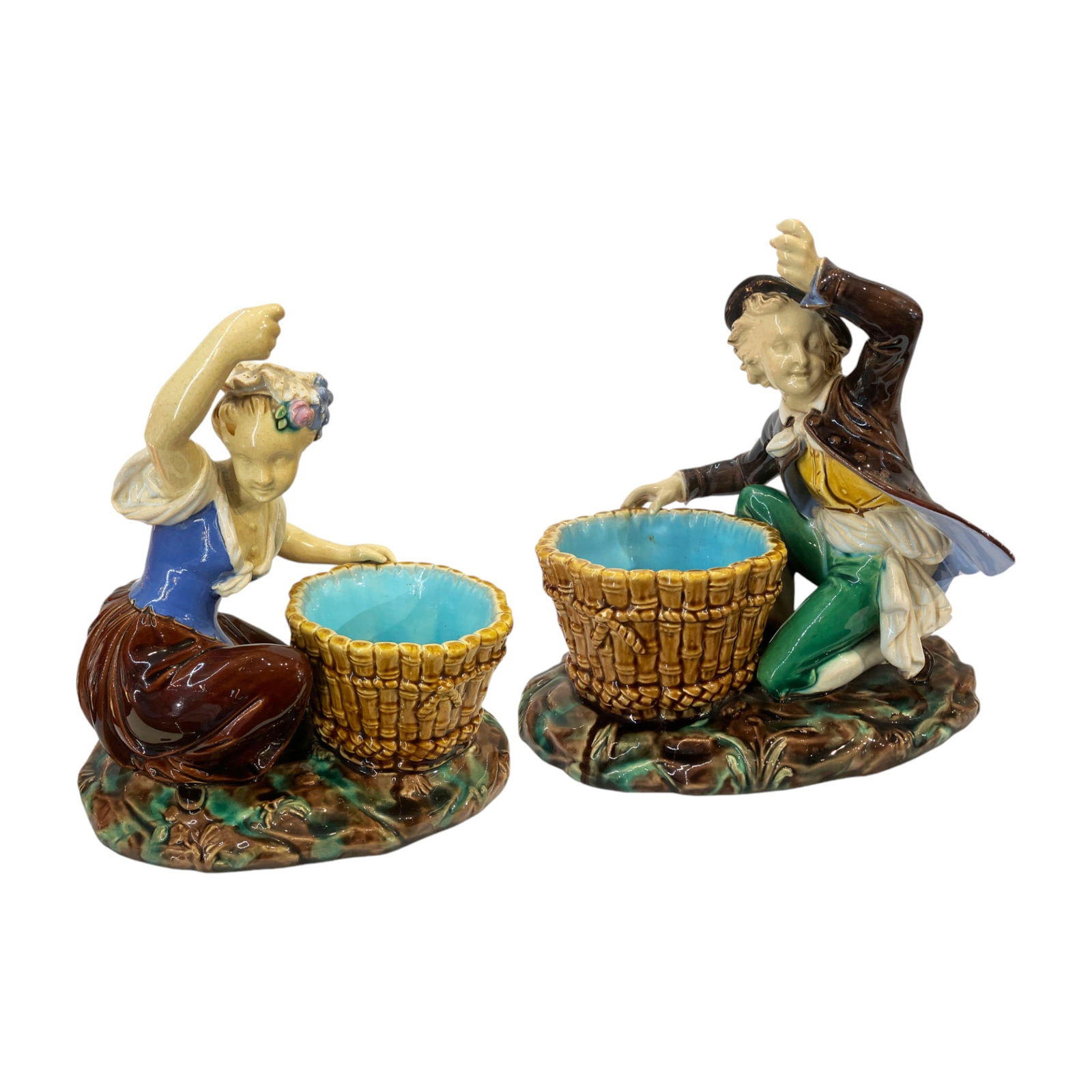 An Early Pair of Minton Majolica: Boy and Girl Flower Holder Posy Holders c.1859, designed by Albert Carrier Belleuse, both dressed in rural costume and with raised arm to form a single flower holder. Impressed date code for 1859 Leng