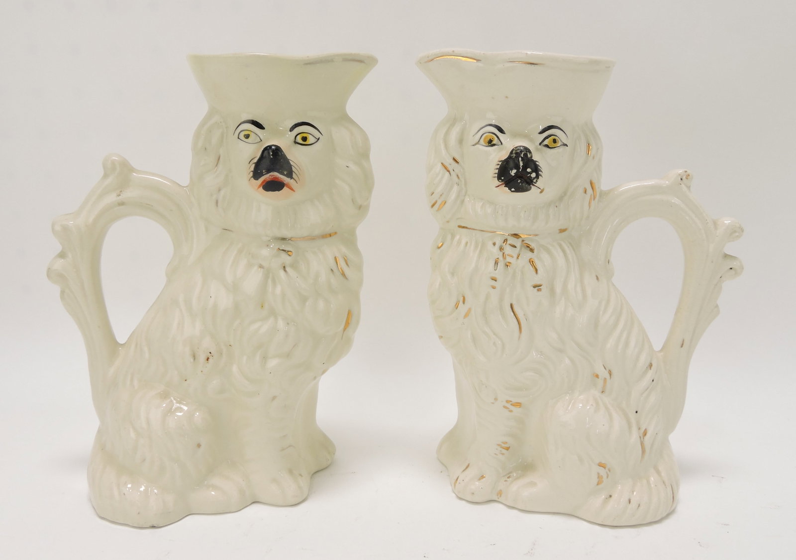 Staffordshire pair of spaniel pitchers,: 7 1/2", one with rim repair