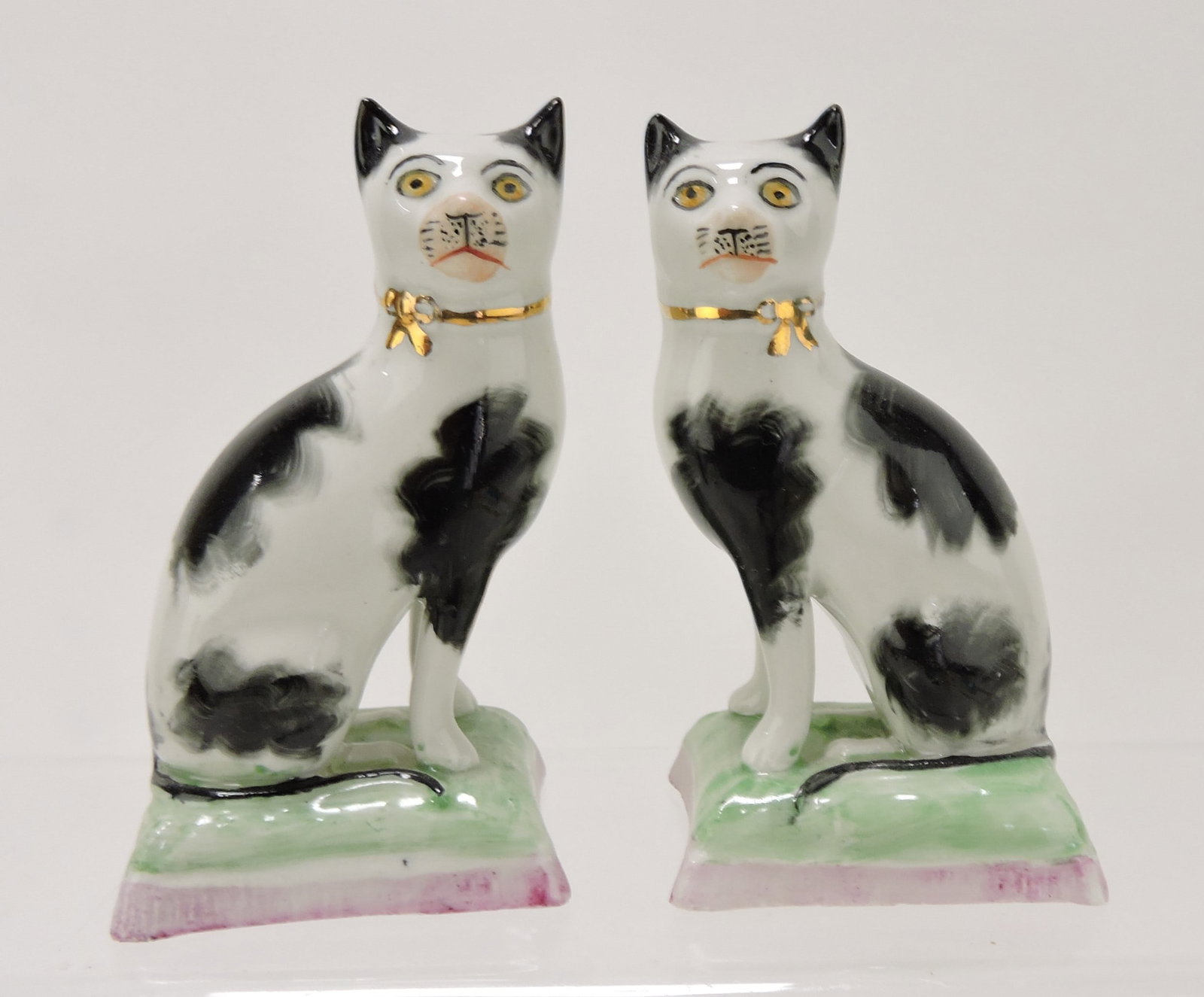 Staffordshire pair of black and white: cats on cushions, 3 3/4"