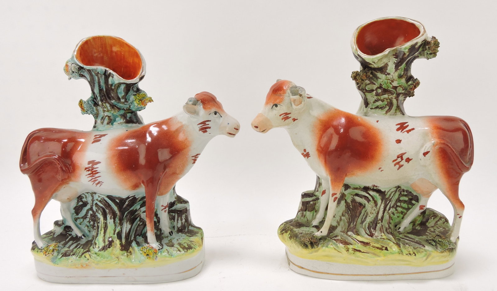 Staffordshire pair of cow spill vases, 9": .