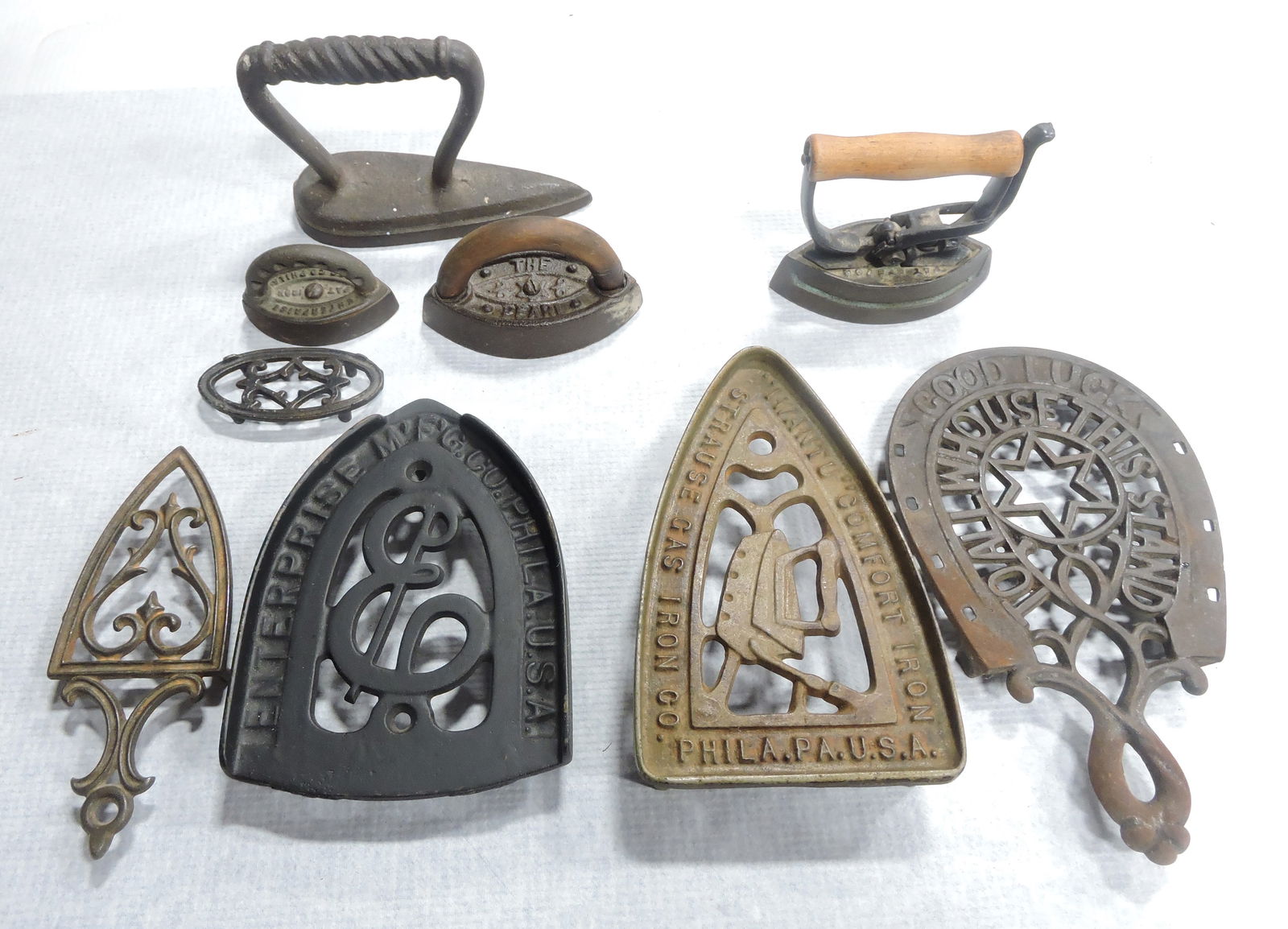 Lot of 5 cast iron trivets and 4 irons: .