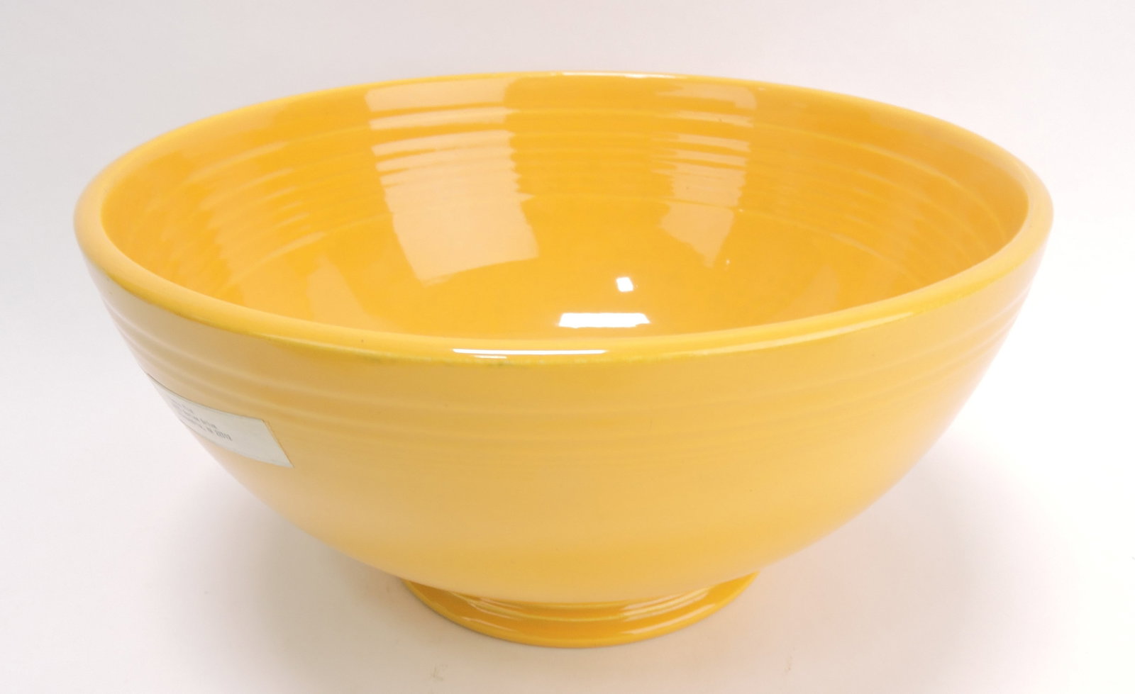 Fiesta footed salad bowl, yellow, minor: rim nick