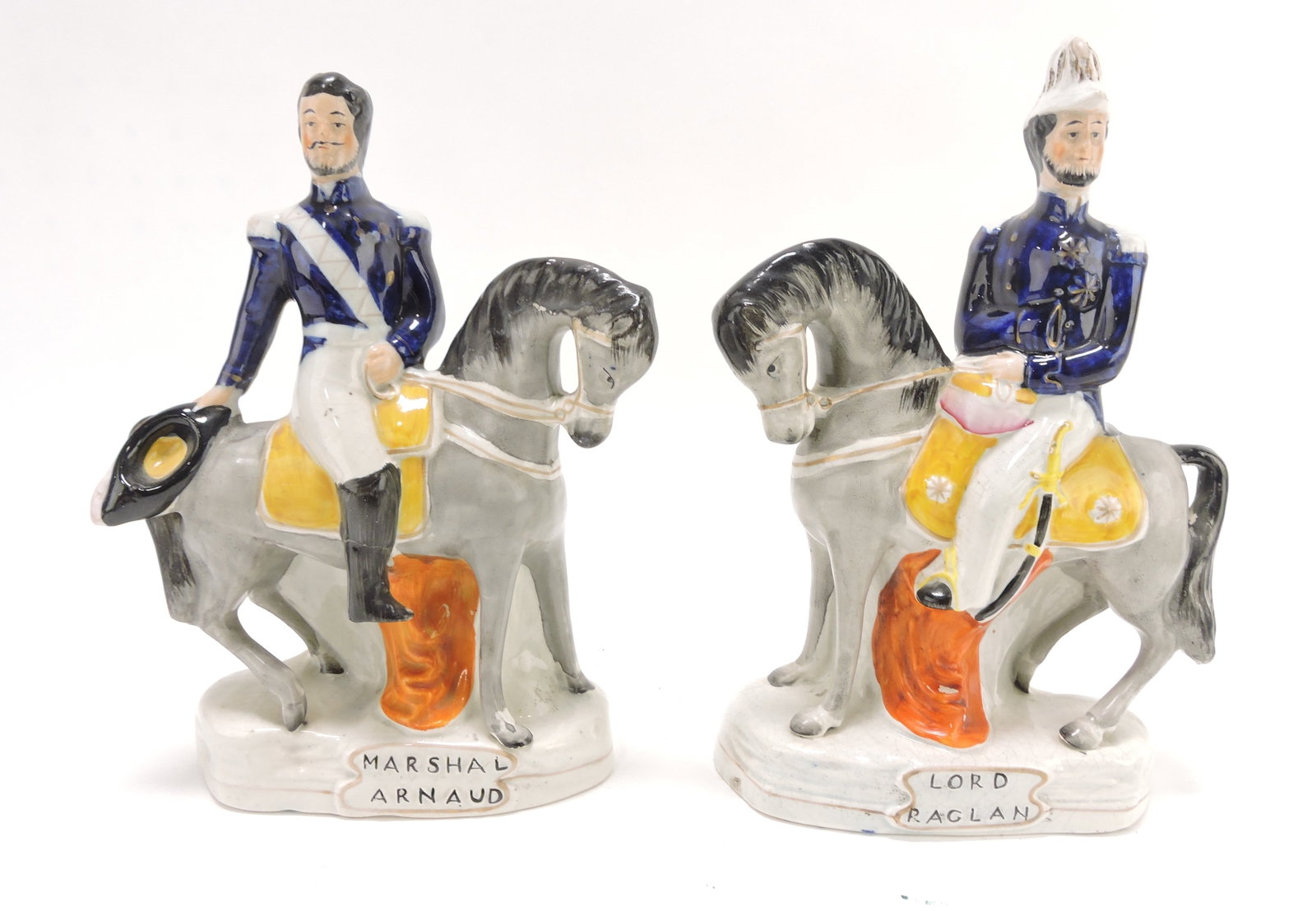 Pair of titled Staffordshire figures of Marshal Arnaud: and Lord Raglan, C. 1854, 11”. Leg repair to Arnaud.