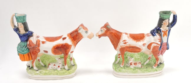 Staffordshire pair of cow spill vases,