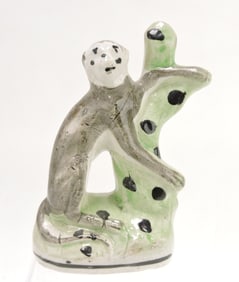 Staffordshire figure of a monkey climbing