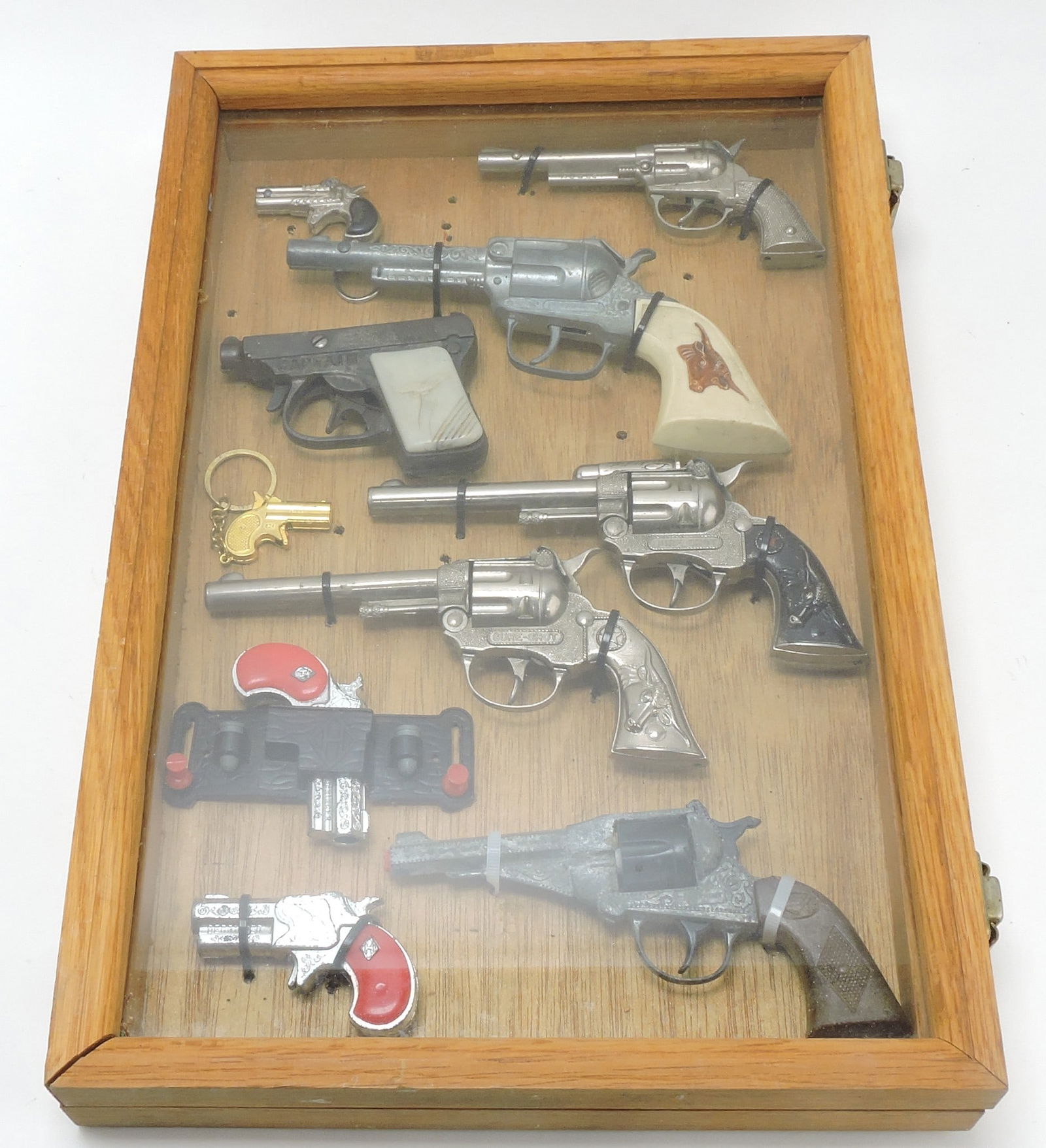 Frame of 10 cap guns and toy guns,: 18"x12"