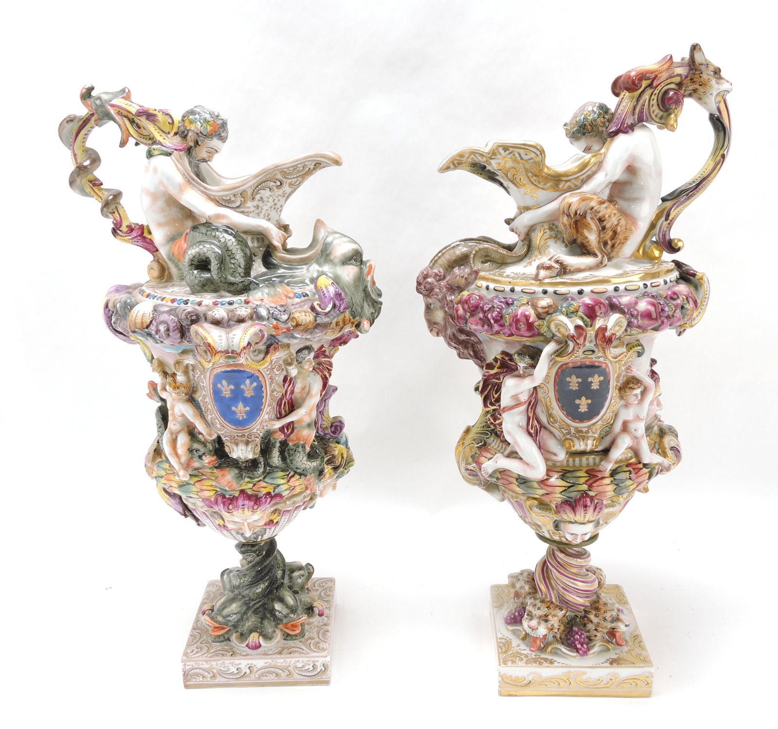 Pair of early porcelain Capodimonte: ewers with elaborate detail of figures and sealife, professional repair to leg of one figure, 17"