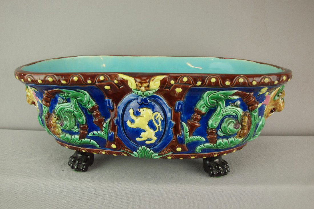 French majolica oval jardiniere with lion mask han: French majolica oval jardiniere with lion mask handles, paw feet, squirrels and lion crest, hiarline to base, 17"l, 7"h