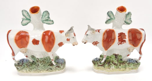 Staffordshire pair of cow spill vases,