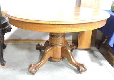 Round oak pedestal dining table with