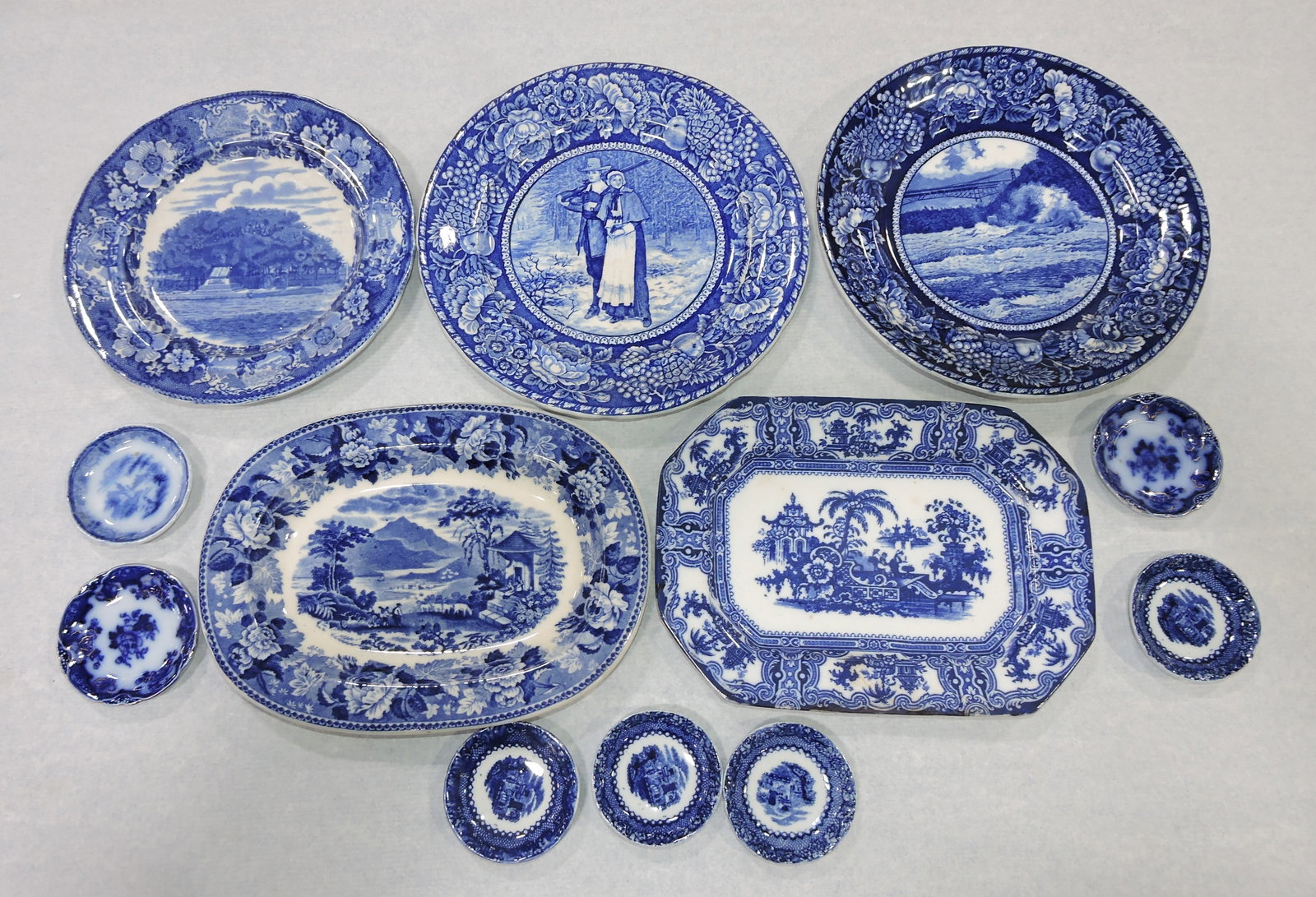 Flow blue Staffordshire lot of 12 plates,: platters, and butter pats, various condition