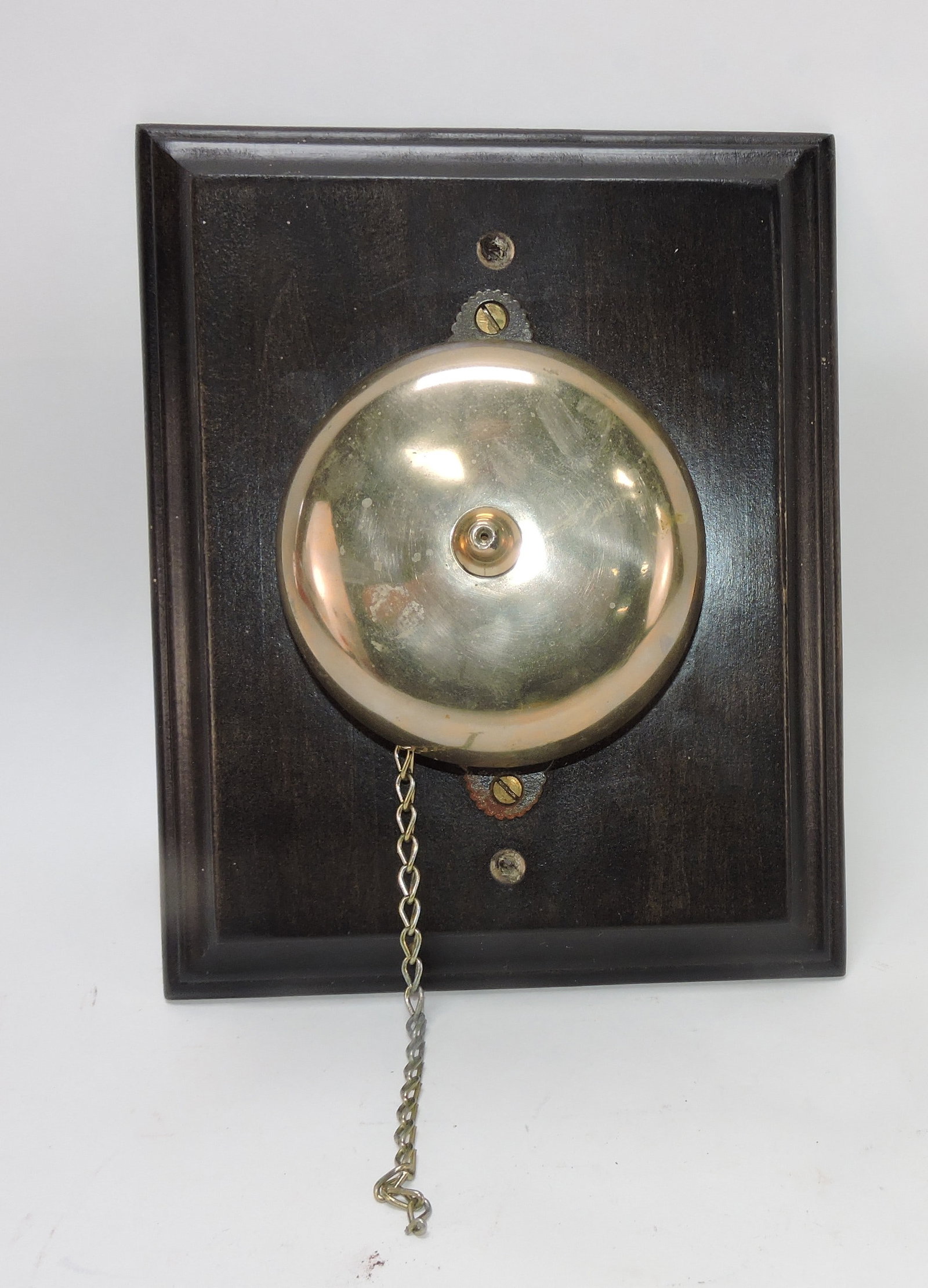 Brass bell (4 1/2') on wooden plaque: .
