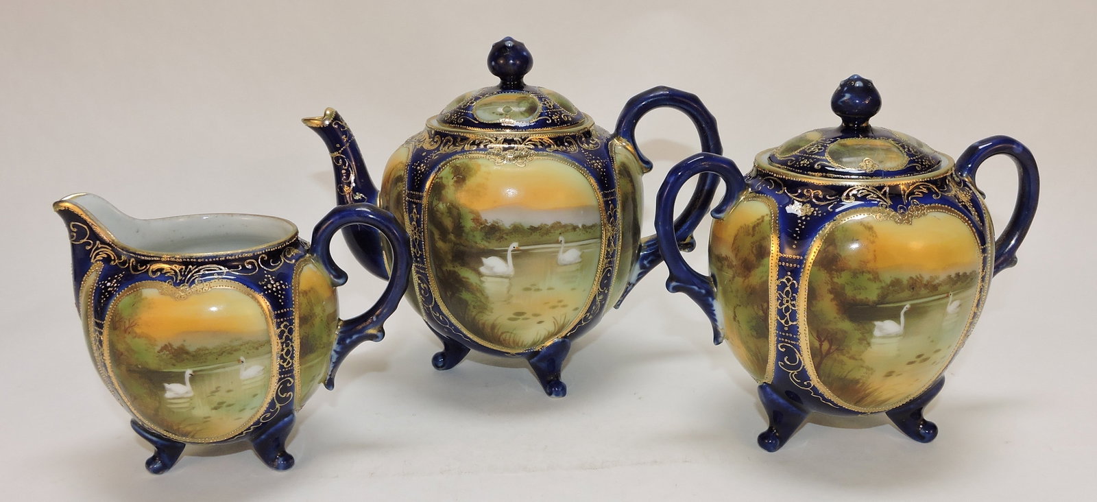 Nippon cobalt and gold 3 pc teaset: with swans, sugar lid repaired. The Dwight & Helen Wilmoth Collection
