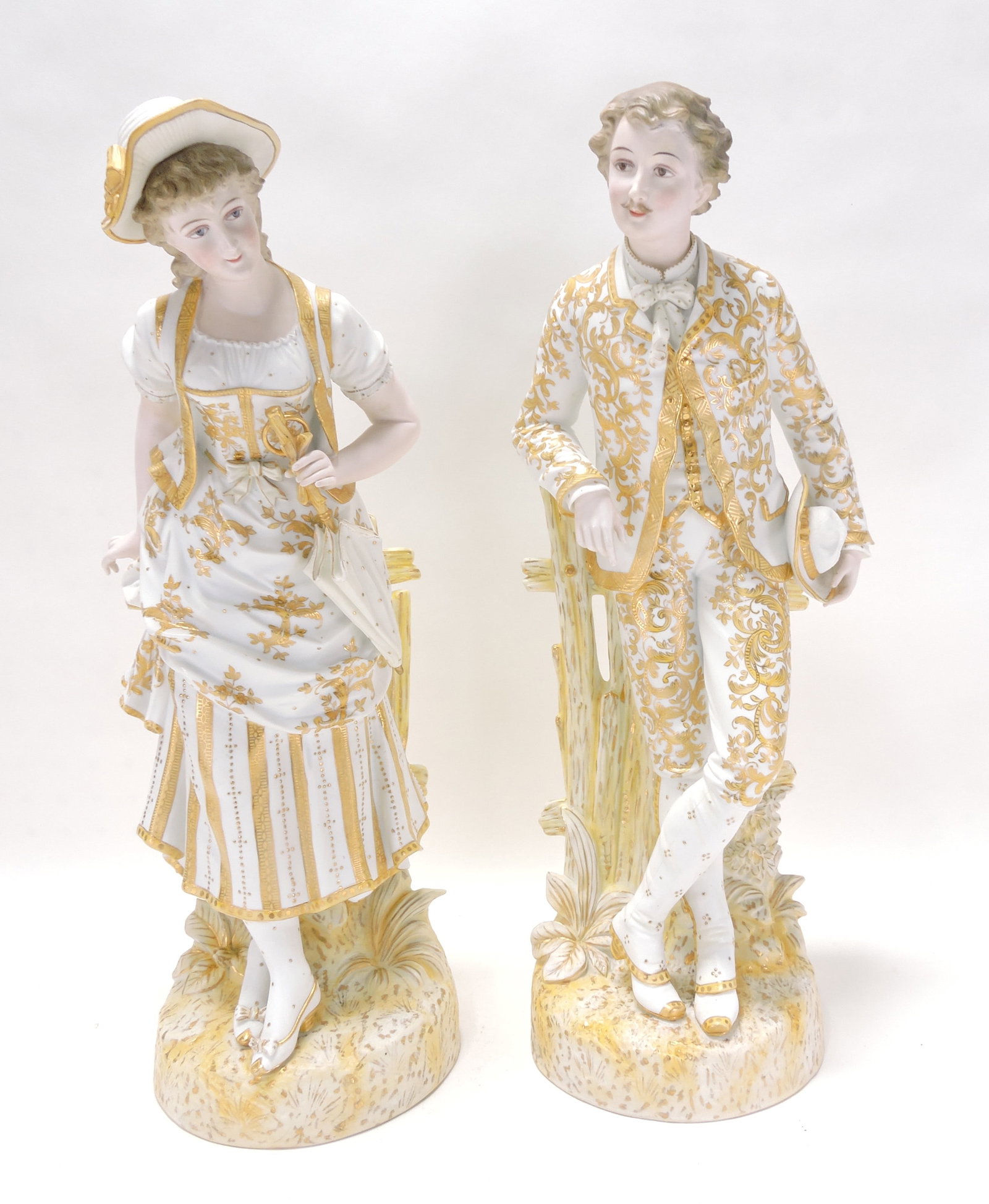 Pair of bisque figures with heavy gold: gilting, 20"
