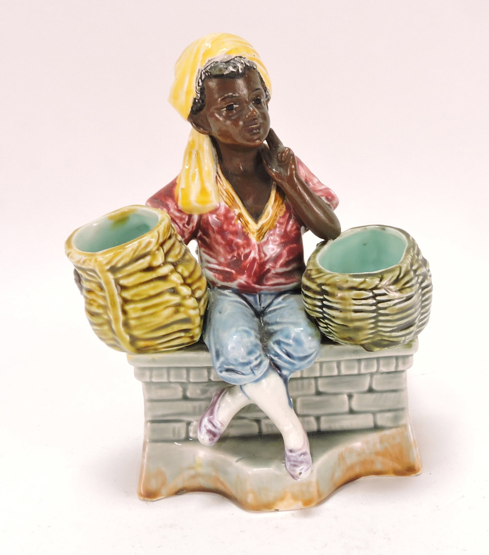 Black Americana majolica figural: match striker of man on bench with basket