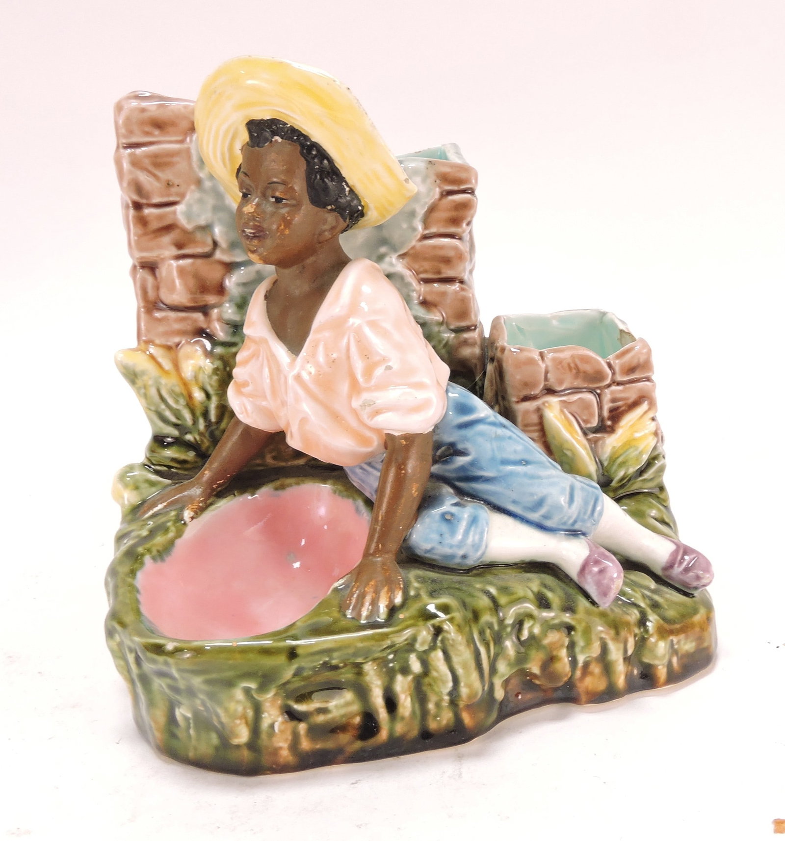 Black Americana majolica figural: match striker of recumbent man, 6"