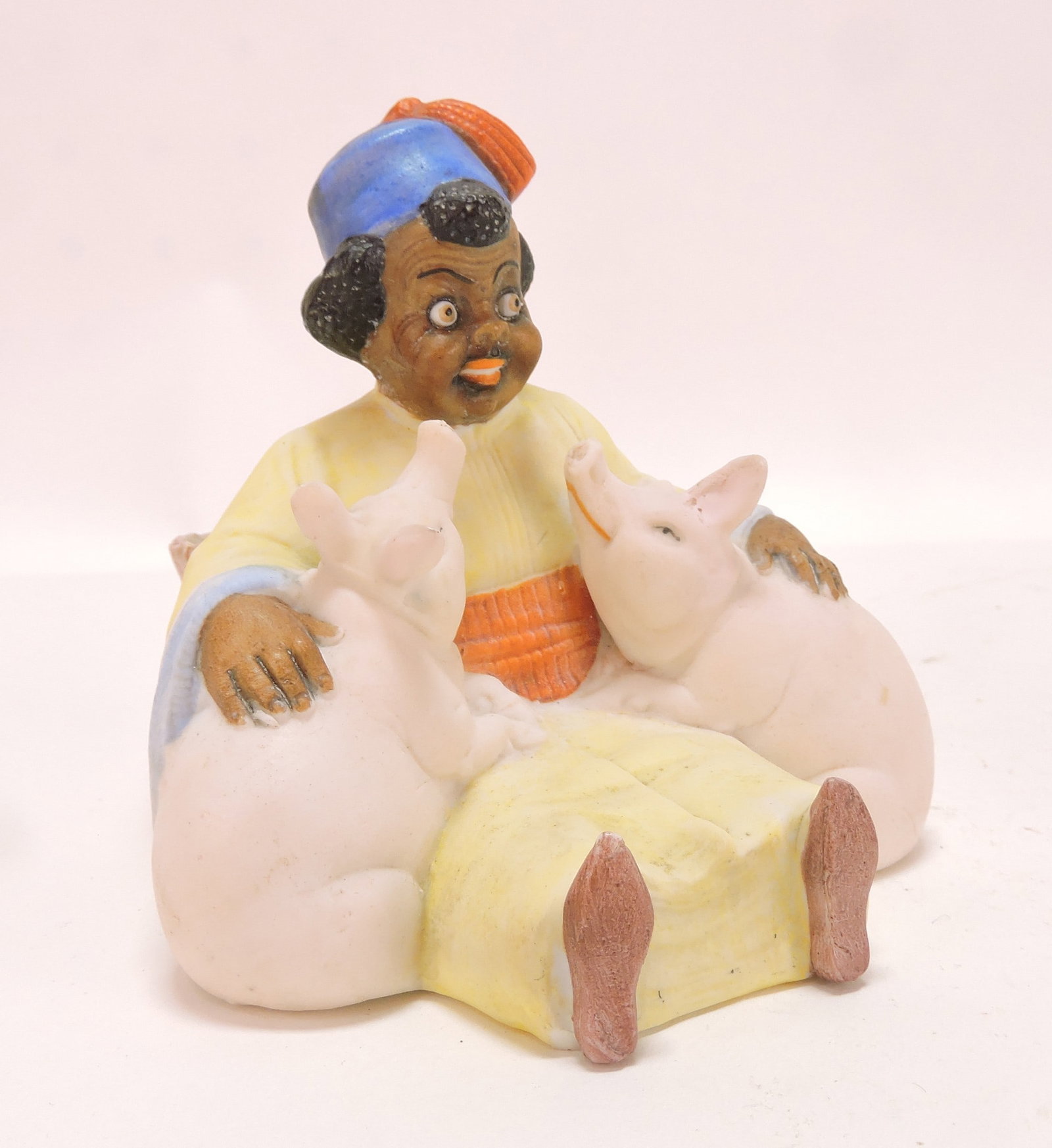Black Americana bisque figural: match holder of boy with pair of pigs, 3 1/2"