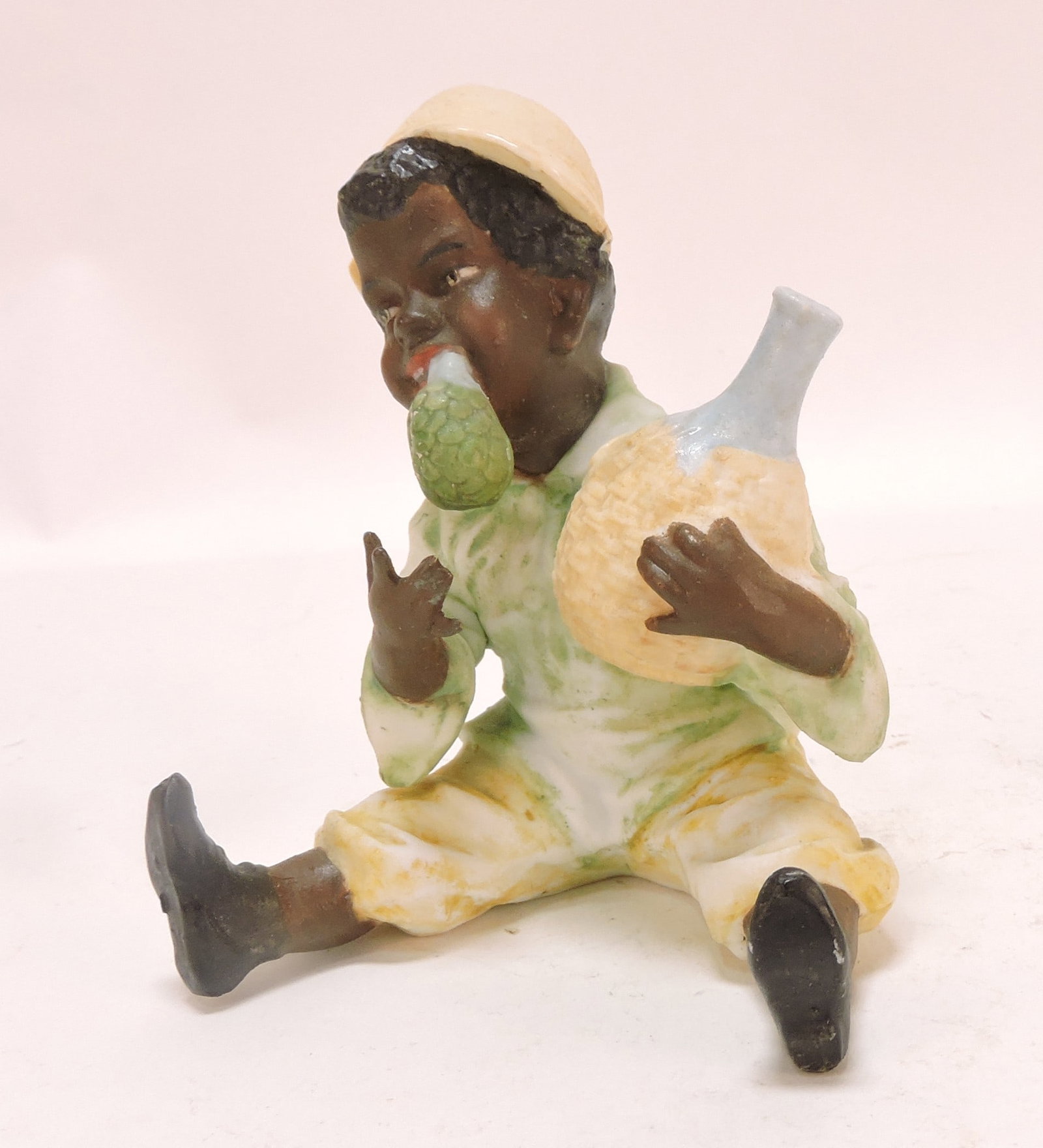 Black Americana bisque figure of boy: with bottle, 4"
