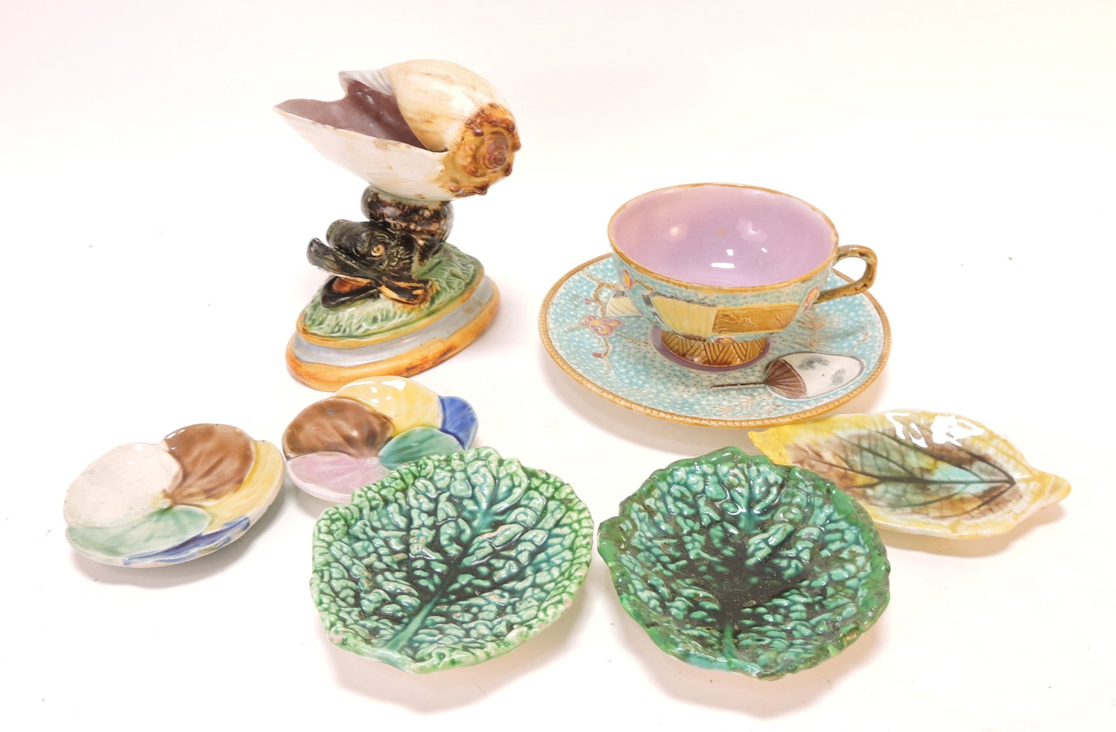 Majolica lot of 5 butter pats, cup & saucer,: and dolphin/shell salt, various condition