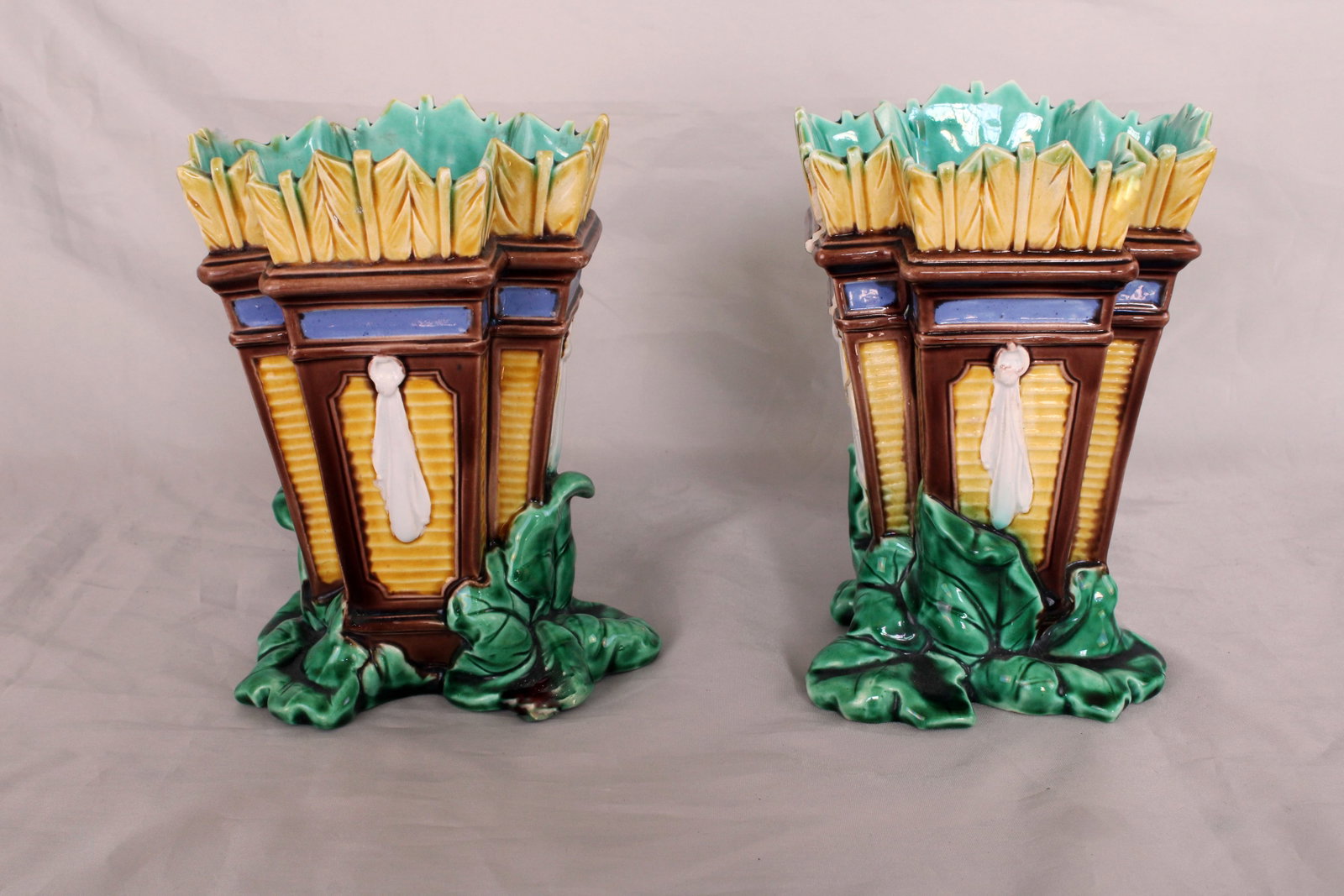 A pair of Wedgwood majolica vases: modelled as a quiver of arrows standing on a leaf base 6 1/2"h, date code for 1863,10”