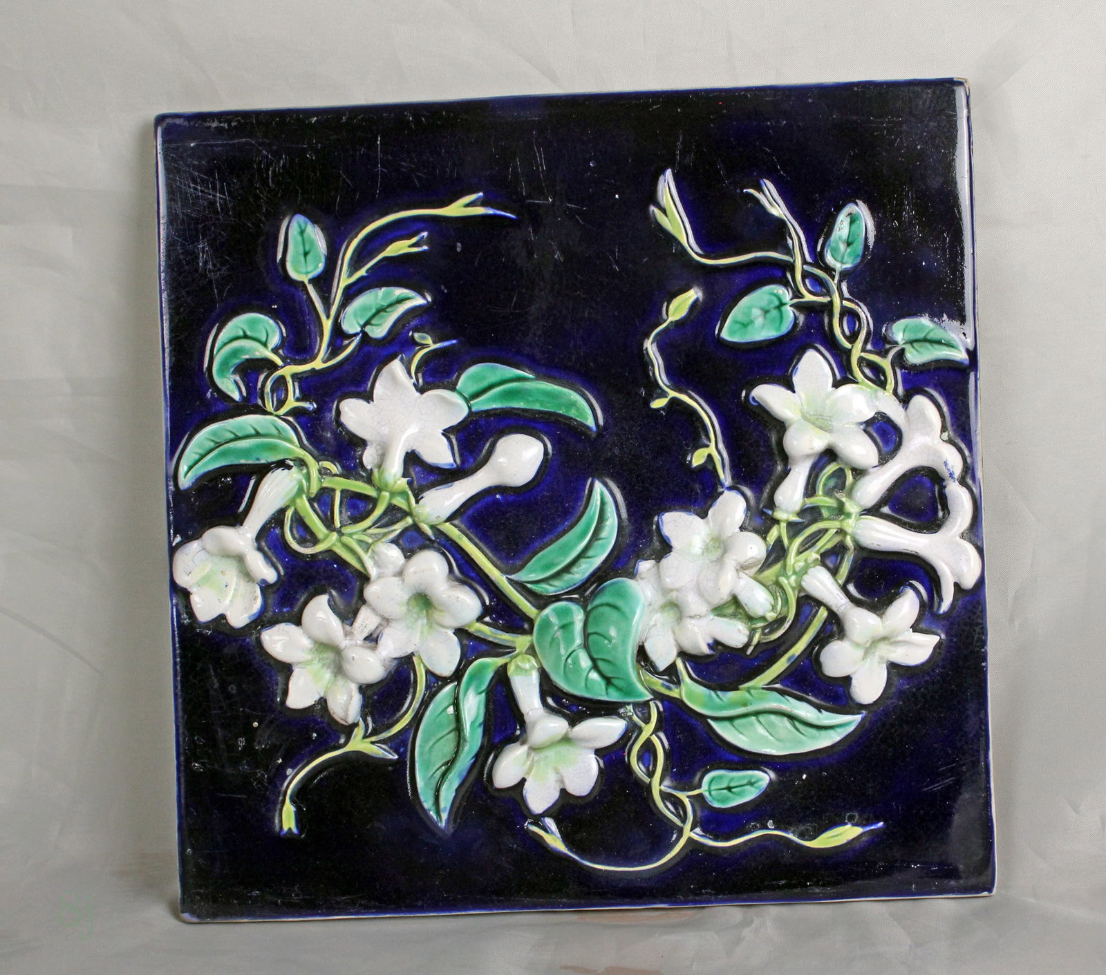 George Jones majolica cobalt ground: stephanotis tile, impressed GJ mark to the back & model no. 3394, 8"