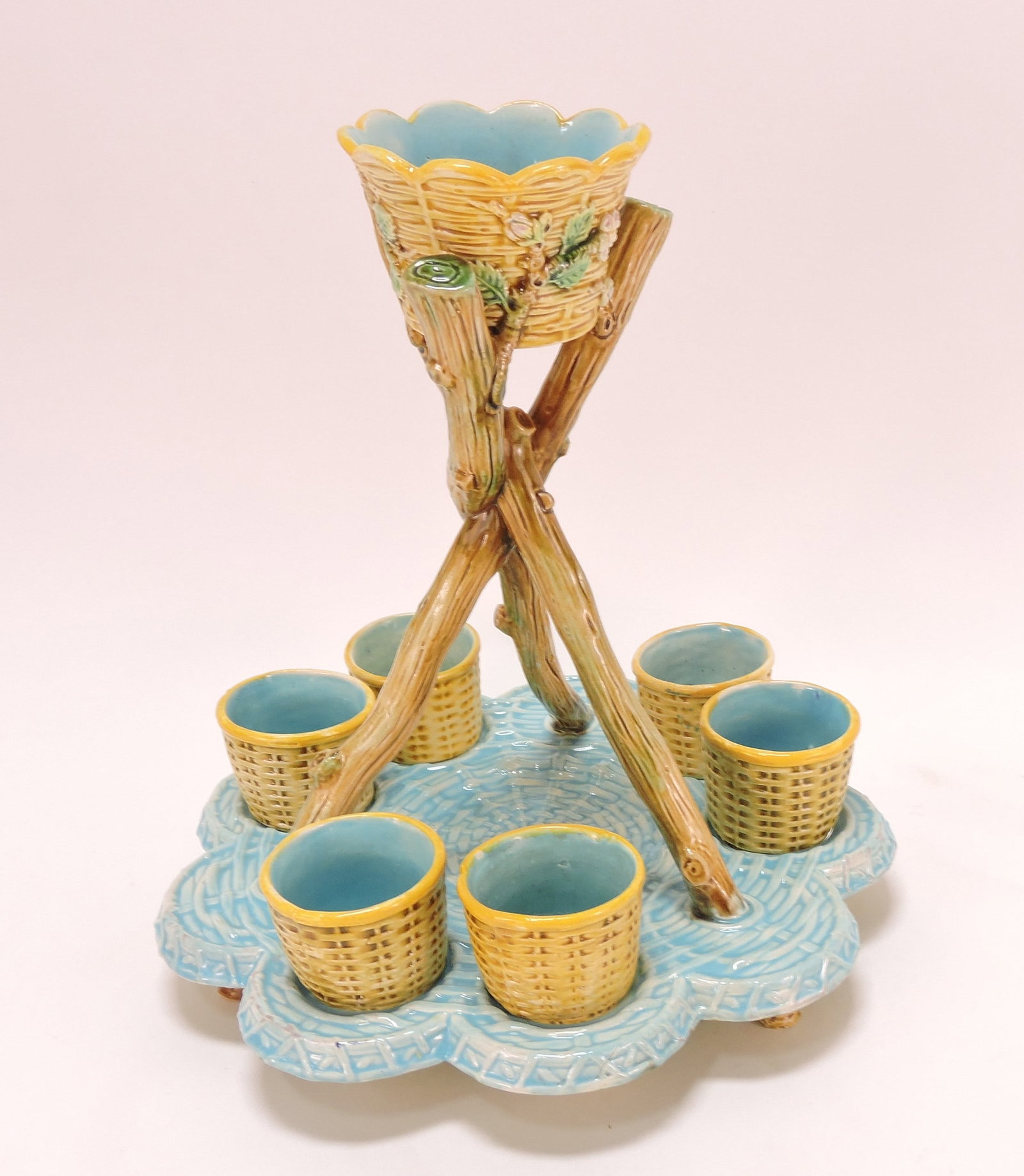 George Jones majolica rare egg cup set: with wicker and twig stand and 6 basket cornucopia egg holders (one replaced), 10"