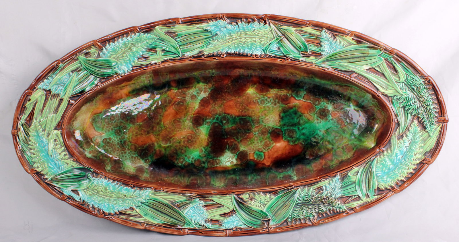 A Rare large George Jones majolica: oval ferns platter with a fern and leaf border in high relief and twig and branch rim on a tortoise shell ground, 26” l, shape no.3291. Ref Majolica Mania vol.2 p 250