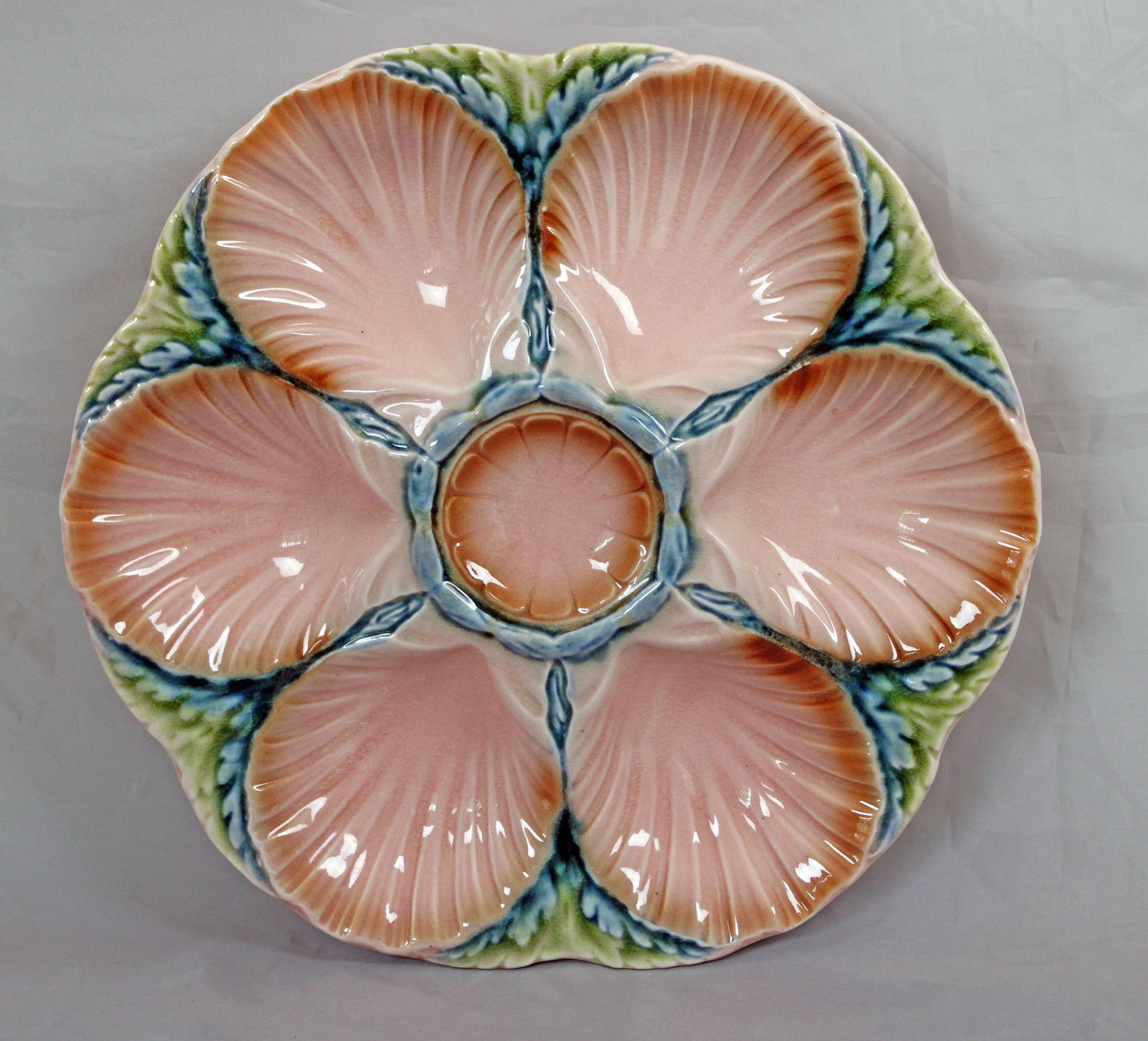 Sarreguemines majolica oyster plate: with six wells separated by seaweed with a central sauce well, 9”