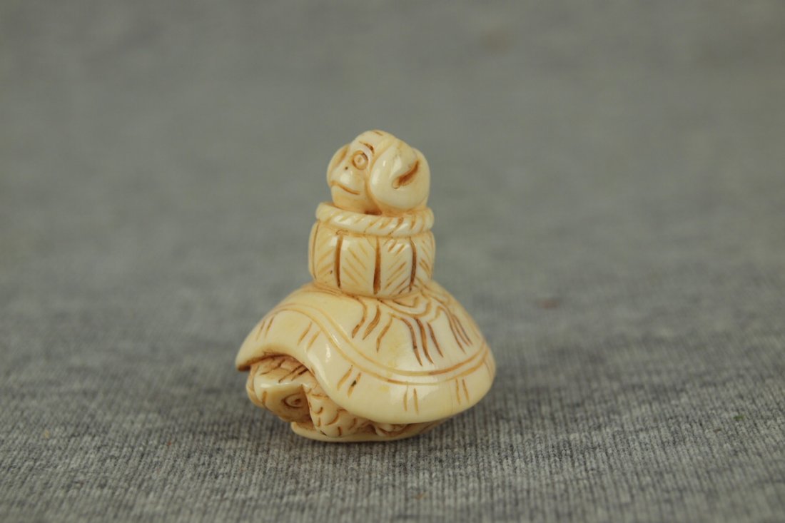 Ivory netsuke of monkey in basket riding turtle, 1 1/2": Ivory netsuke of monkey in basket riding turtle, 1 1/2"