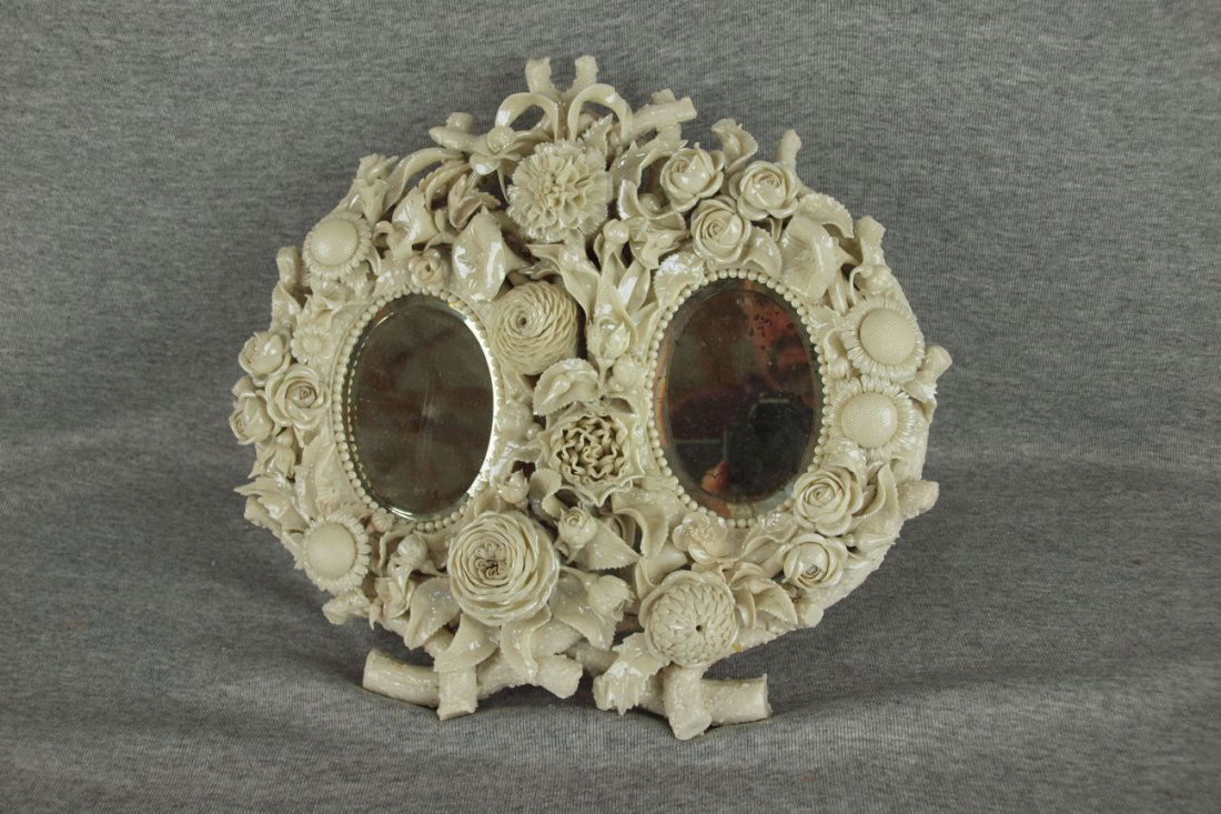 Early Irish Belleek rare double beveled glass mirror: Early Irish Belleek rare double beveled glass mirror with three dimensional flowers and leaves, repair to leg and branch on top, early black mark, 12"w, 11"h, some loss to mirror silvering