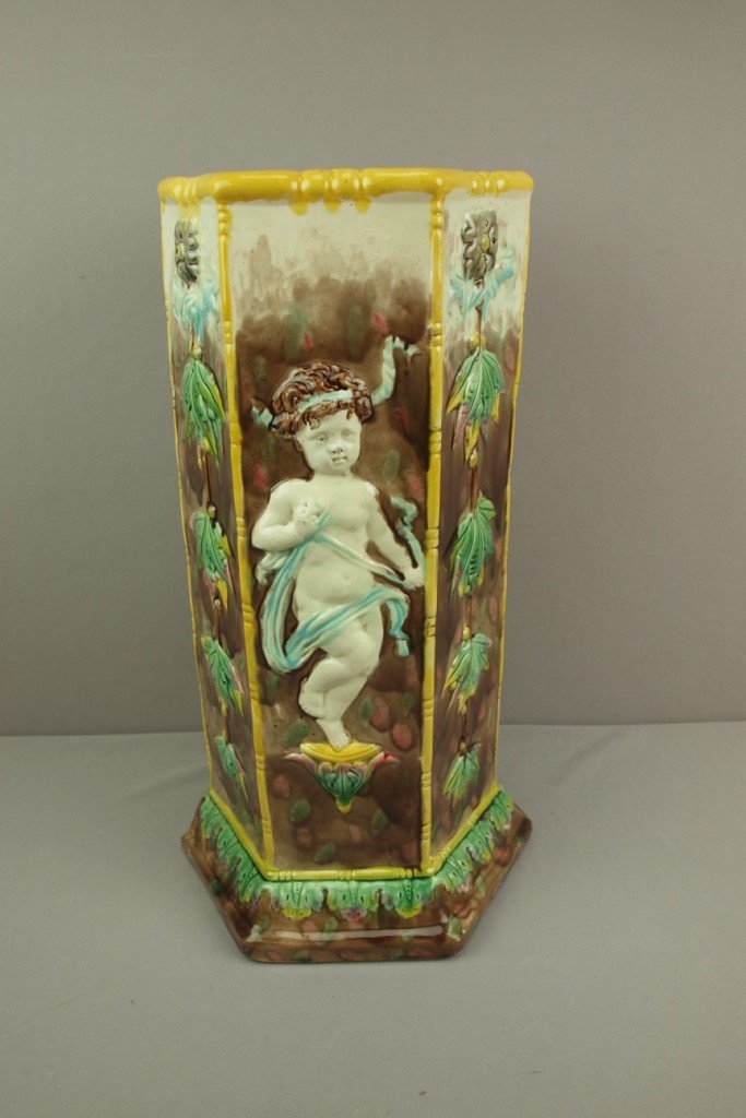 Majolica umbrella stand with putti and leaves on: Majolica umbrella stand with putti and leaves on panels, 20"h, large base chips