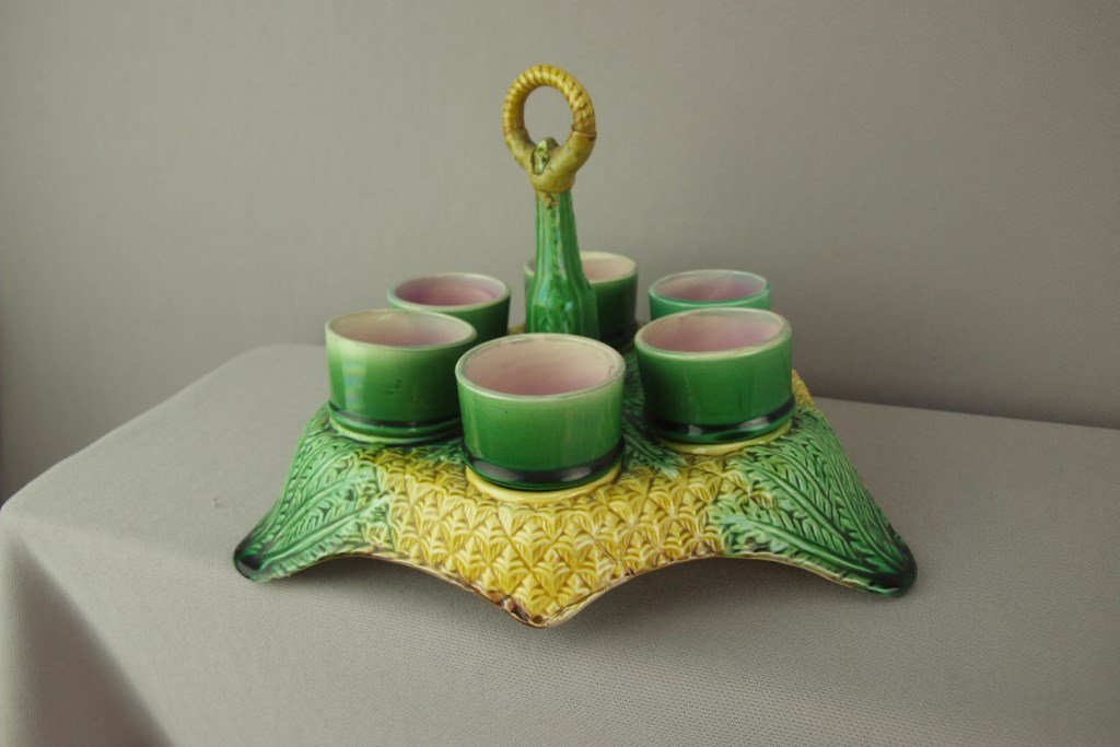 Majolica pineapple egg cup holder with 6 egg cups,: Majolica pineapple egg cup holder with 6 egg cups, repair to handle of holder and minor base rim nick