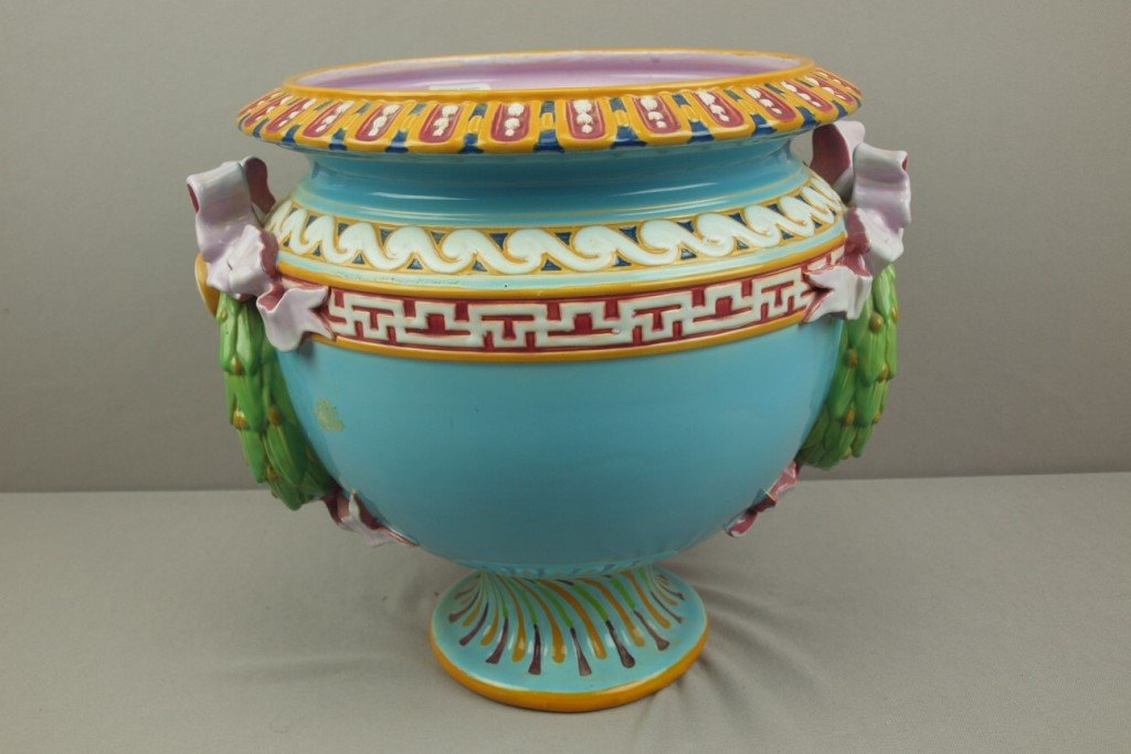 MINTON turquoise majolica jardiniere with laurel wreath: MINTON turquoise majolica jardiniere with laurel wreath handles tied with pink ribbon and bows, 13"h, 15"w, professional repair to base rim