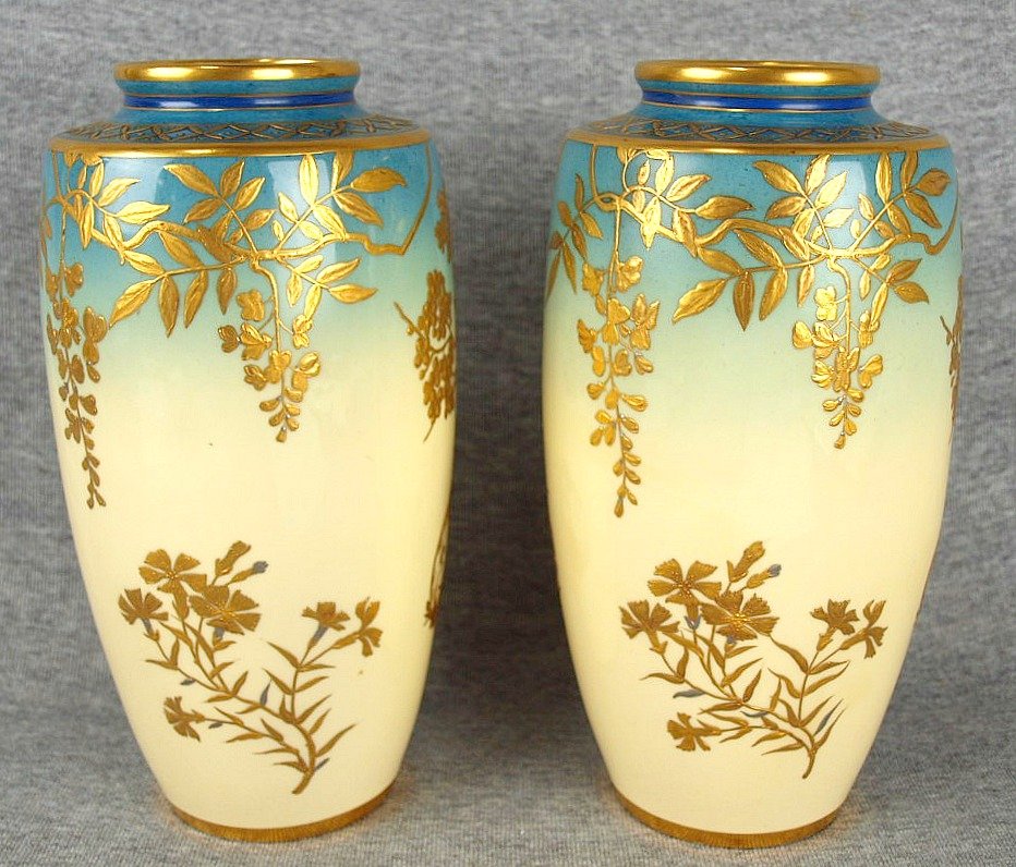 A fine quality pair of Minton aesthetic movement bone: A fine quality pair of Minton aesthetic movement bone china vases in pale blue and yellow decorated with gilded Japanese 22ct gold and platinum decoration, c1890, 9", one with fine body crack