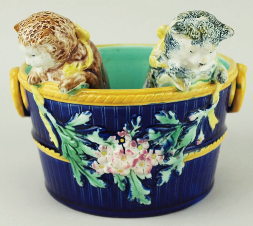 A very rare and charming Majolica posy holder modeled: A very rare and charming Majolica posy holder modeled as a cobalt blue half barrel with bright yellow ring handles, rope twist to top edge and middle, the body with a large spray of brightly glazed bl
