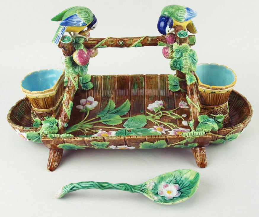 An iconic and charming George Jones Majolica: An iconic and charming George Jones Majolica Strawberry server and spoon modeled as a brown strawberry trugg decorated with strawberry leaves and flowers with a trellis above with entwined strawberrie