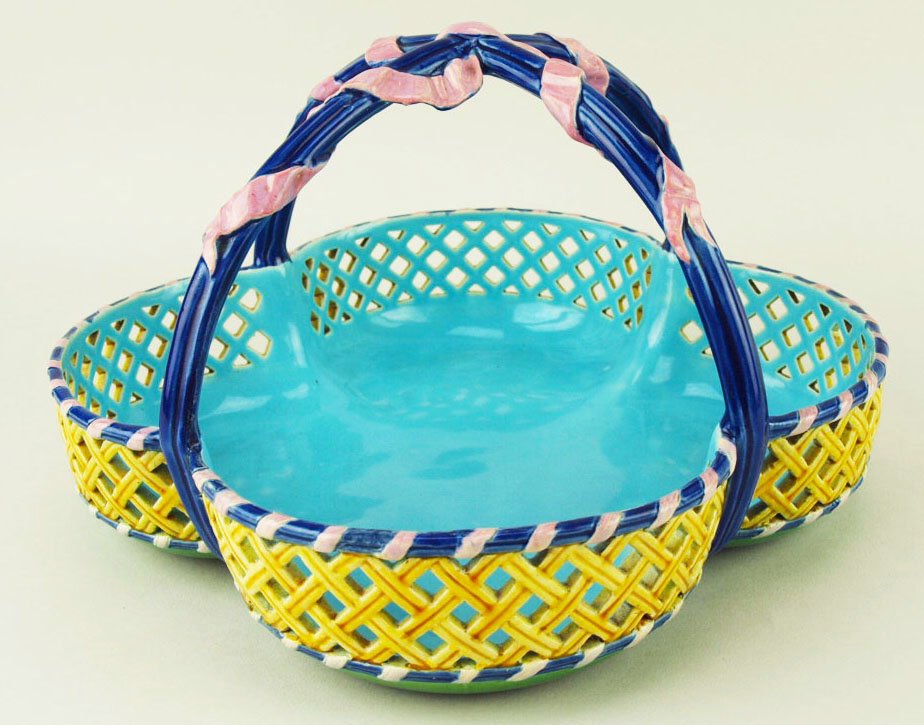 A very rare and delicate Minton Majolica posy basket: A very rare and delicate Minton Majolica posy basket designed as a profusely carved quatrefoil shaped yellow bowl with a turquoise interior and a top and bottom edge of cobalt blue with pink ribbon. T
