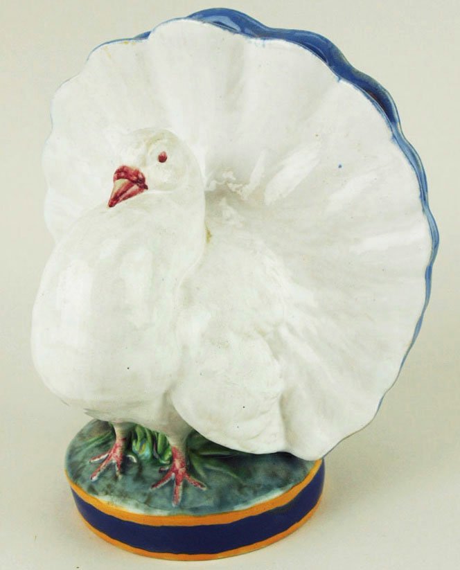 An elegant Minton Majolica posy vase in the form of a: An elegant Minton Majolica posy vase in the form of a plump white dove with its tail feathers fanned. The opening for the flowers glazed in French blue and the circular base decorated in bands of coba