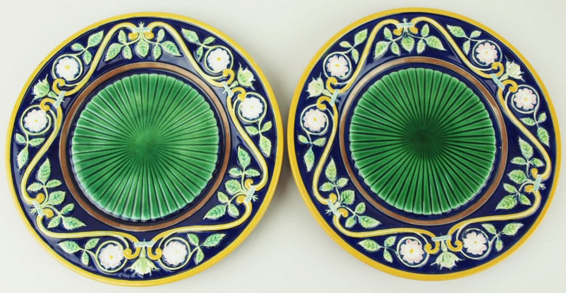 A pair of George Jones dessert plates decorated with: A pair of George Jones dessert plates decorated with radiating emerald green centres, a deep cobalt blue border, and stylized scrolling, leaves and blossoms with an orange border, 9” 'CURATED & CATA