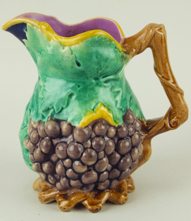 A fine T.C. Brown Westhead Moore and Co. grapes: A fine T.C. Brown Westhead Moore and Co. grapes pitcher c.1875, height 6”, the body modeled as a large bunch of purple grapes with large green vines leaves wrapping around the shoulders, a pink inte