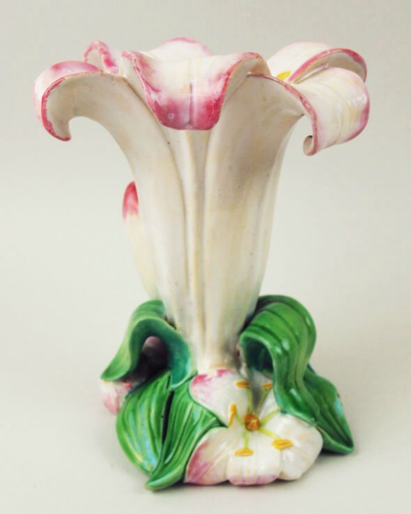 A very rare and pretty Minton Majolica lily vase.: A very rare and pretty Minton Majolica lily vase. c.1875, the vase designed as an upright white lily with pink petal tips and yellow stamens with a base of green leaves and smaller lily heads, 6” 'C