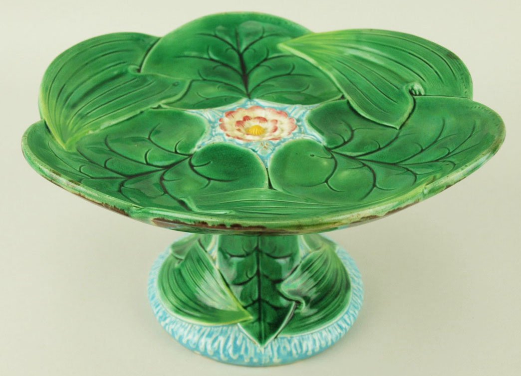 A George Jones Majolica ‘Lotus’ compote c.1875, the: A George Jones Majolica ‘Lotus’ compote c.1875, the top modeled as overlapping lotus leaves with a single pink and white flower to the centre floating in turquoise water, the pedestal base formed 